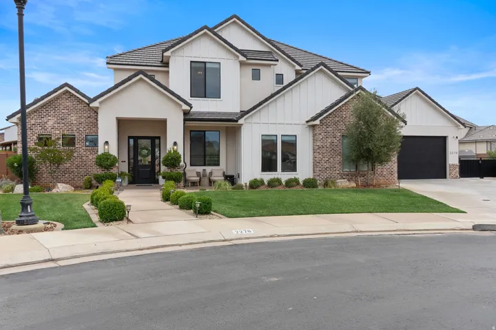Contemporary residence featuring a stucco and brick exterior with board and batten accents.