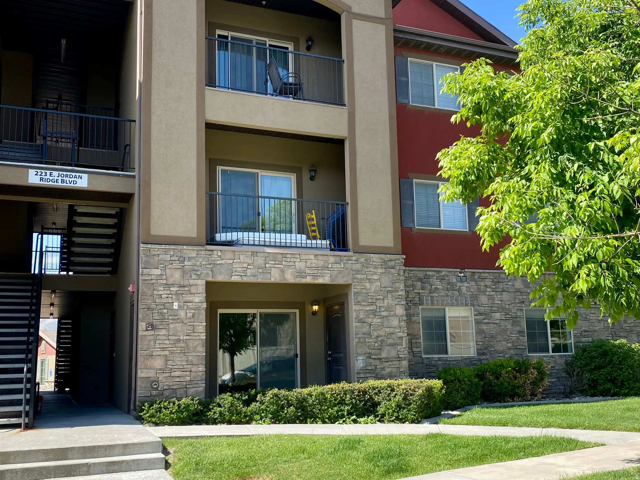 Multi-story building featuring a stone veneer base and stucco exterior