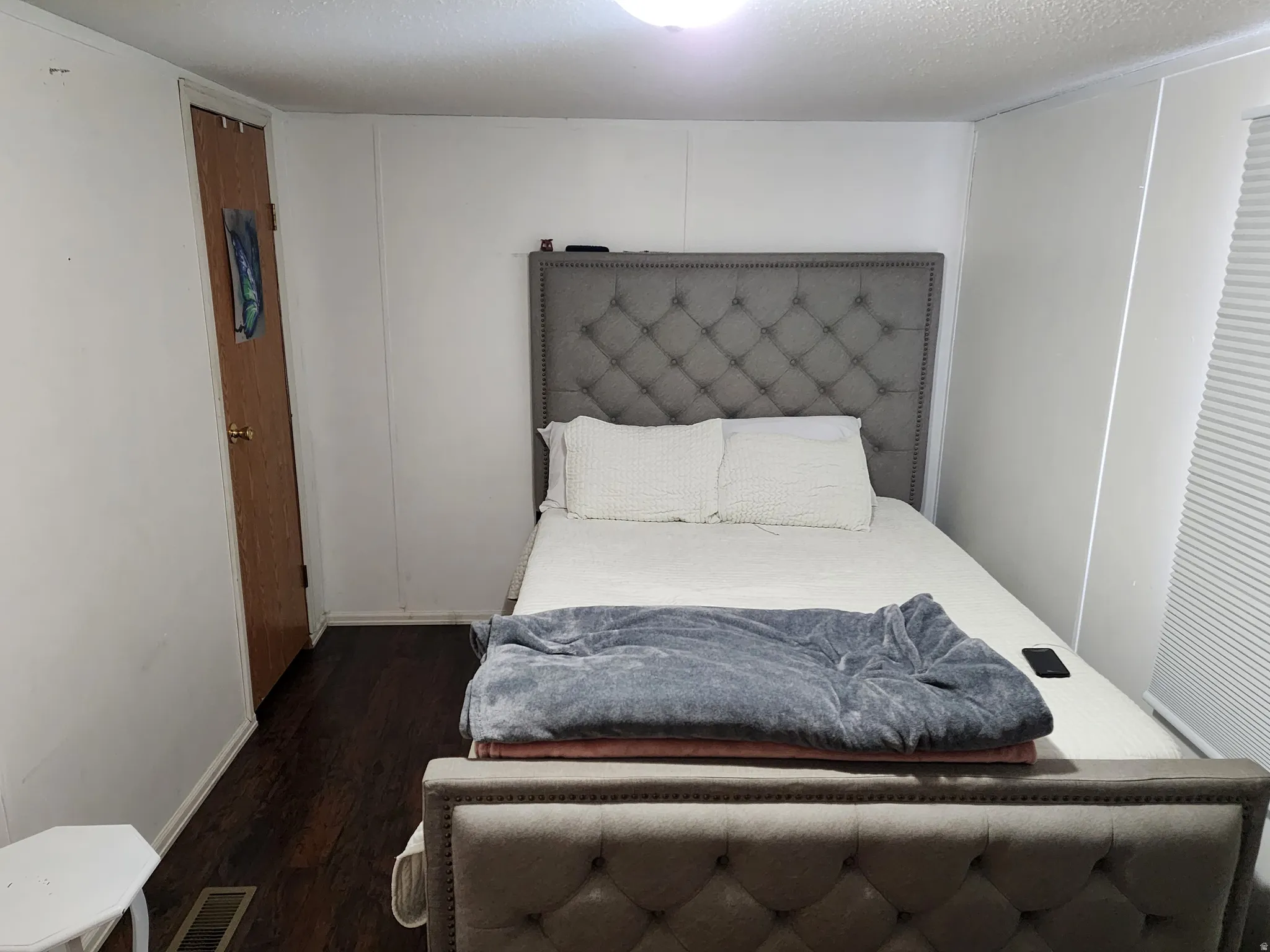 Bedroom featuring dark wood-finish flooring and white walls