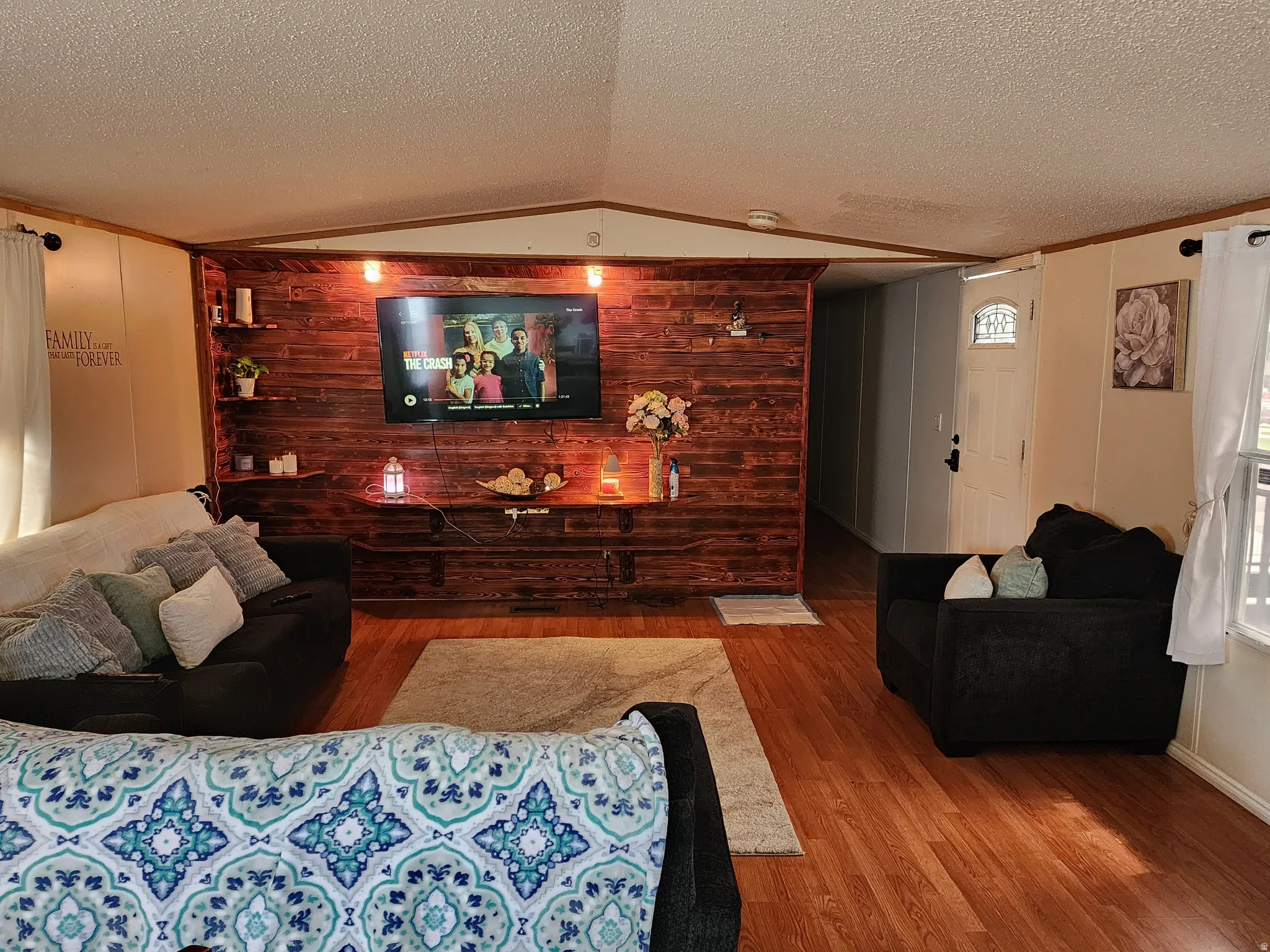 Living area featuring a prominent wood-panel accent wall with built-in shelving