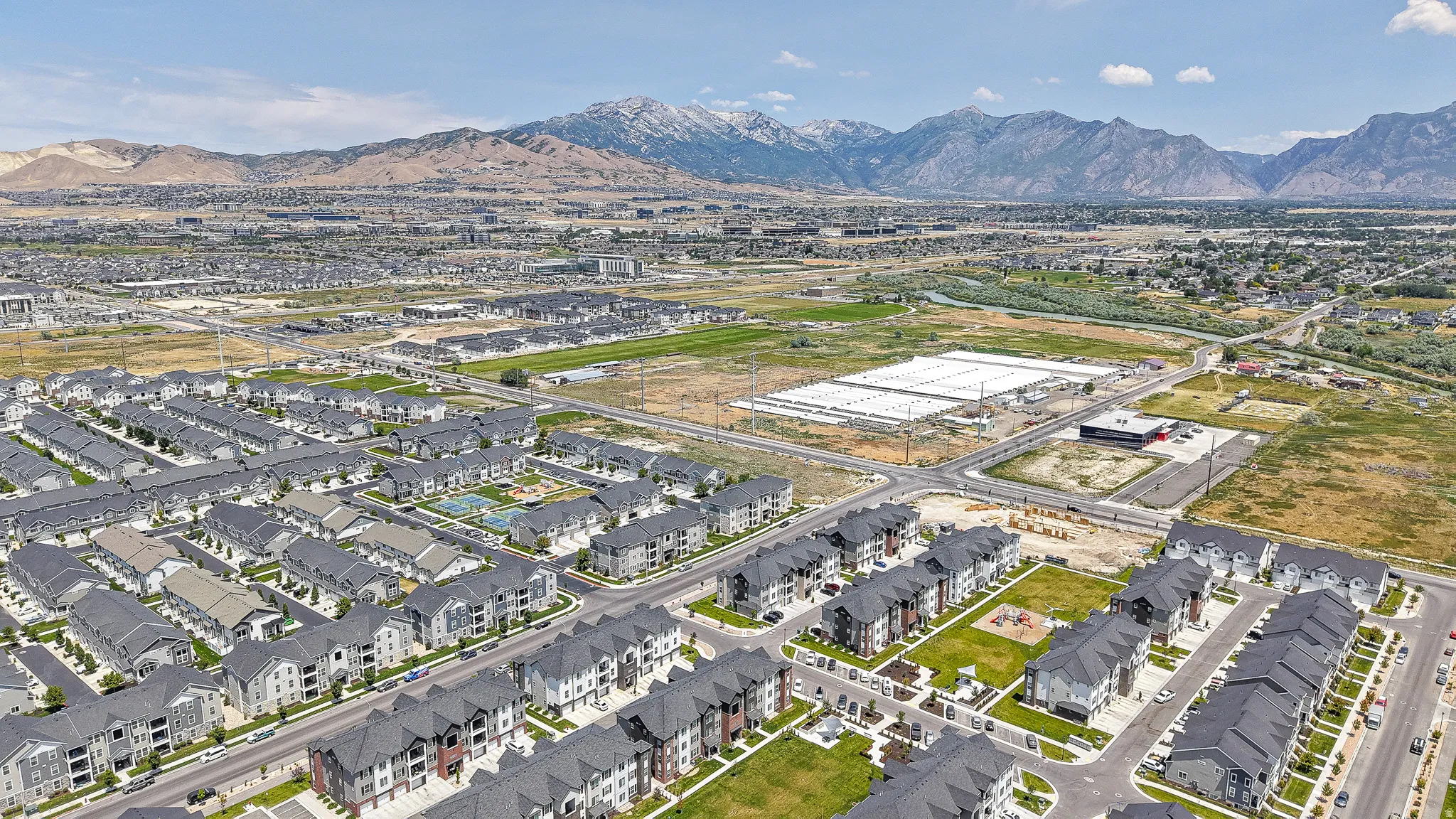 Aerial perspective showcasing an expansive residential development with numerous multi-story buildings and townhomes