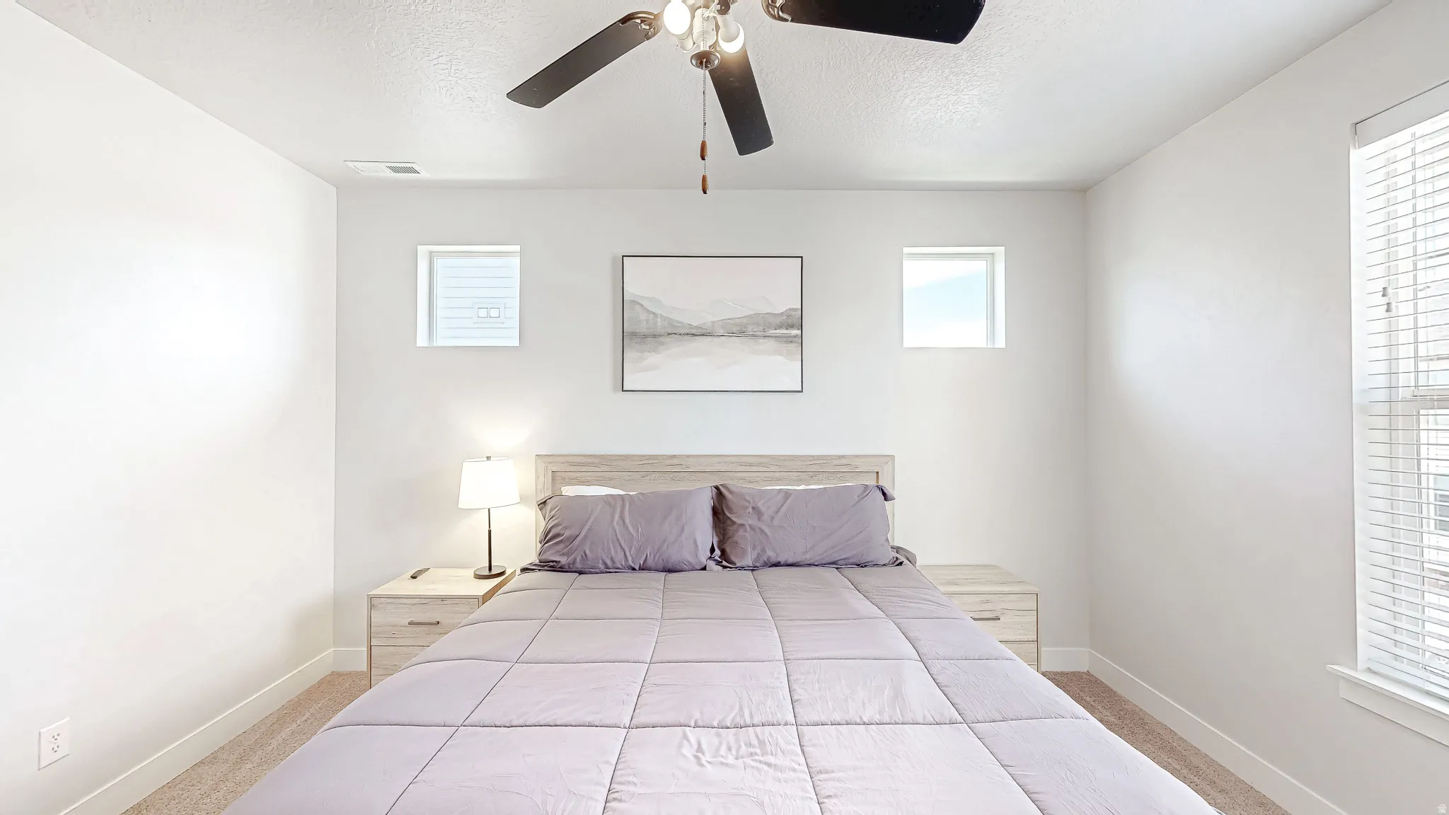 Spacious room featuring neutral carpeting, a ceiling fan with integrated lighting, and white trim