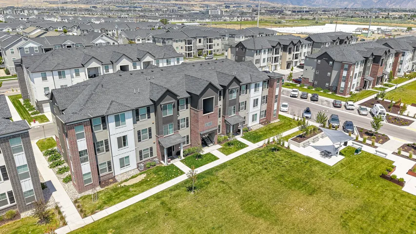 Multi-story residences featuring brick and siding exteriors with dark shingle roofs, balconies, and ground-level patios