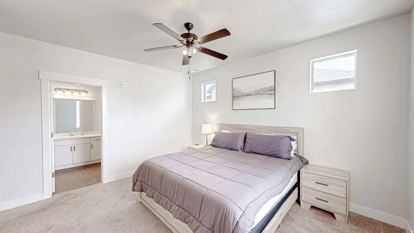 Bedroom featuring light-toned carpeting and a ceiling fan with integrated lighting