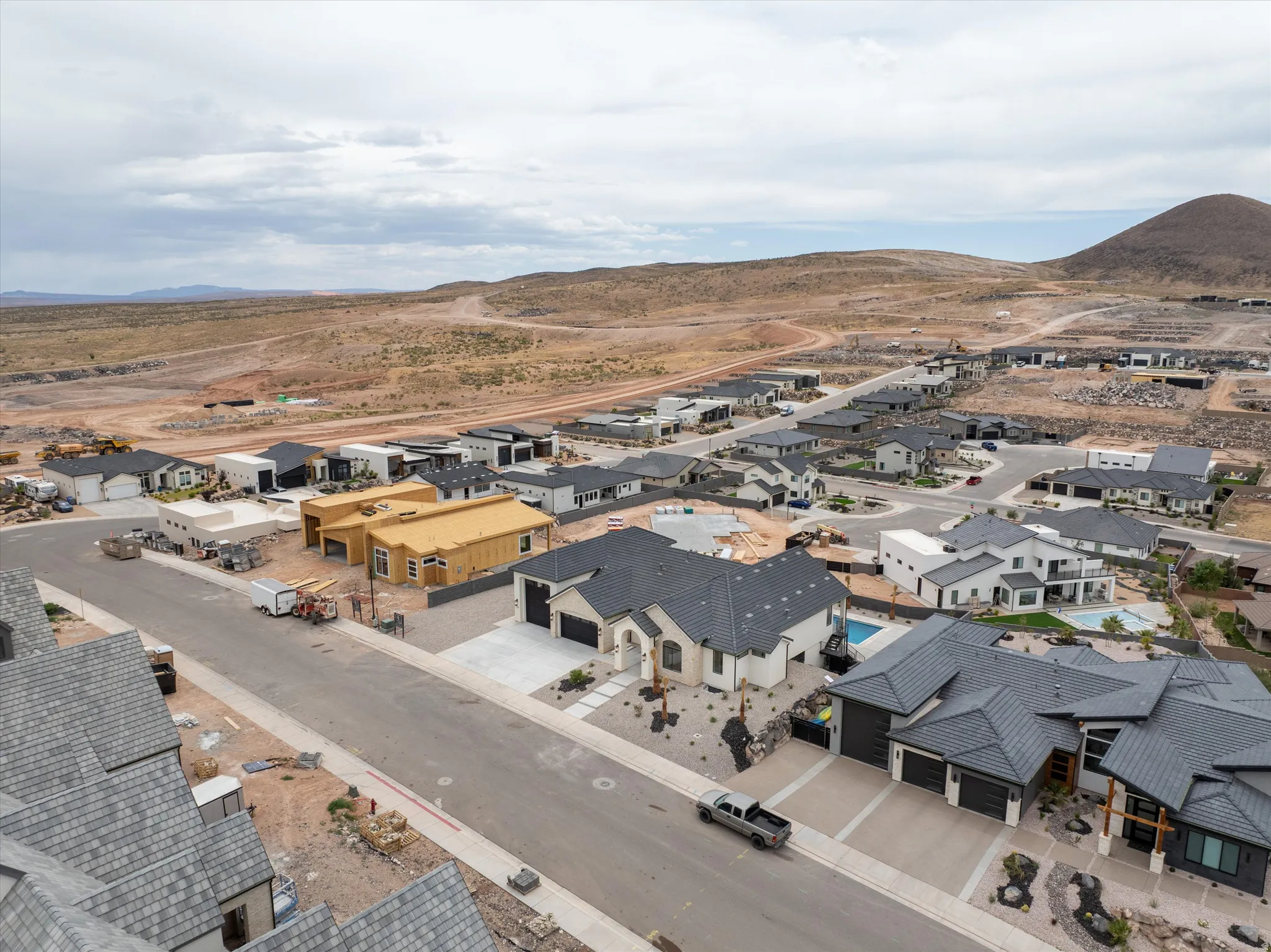 Expansive neighborhood featuring varied architectural styles and desert landscaping, with numerous completed residences and properties under construction