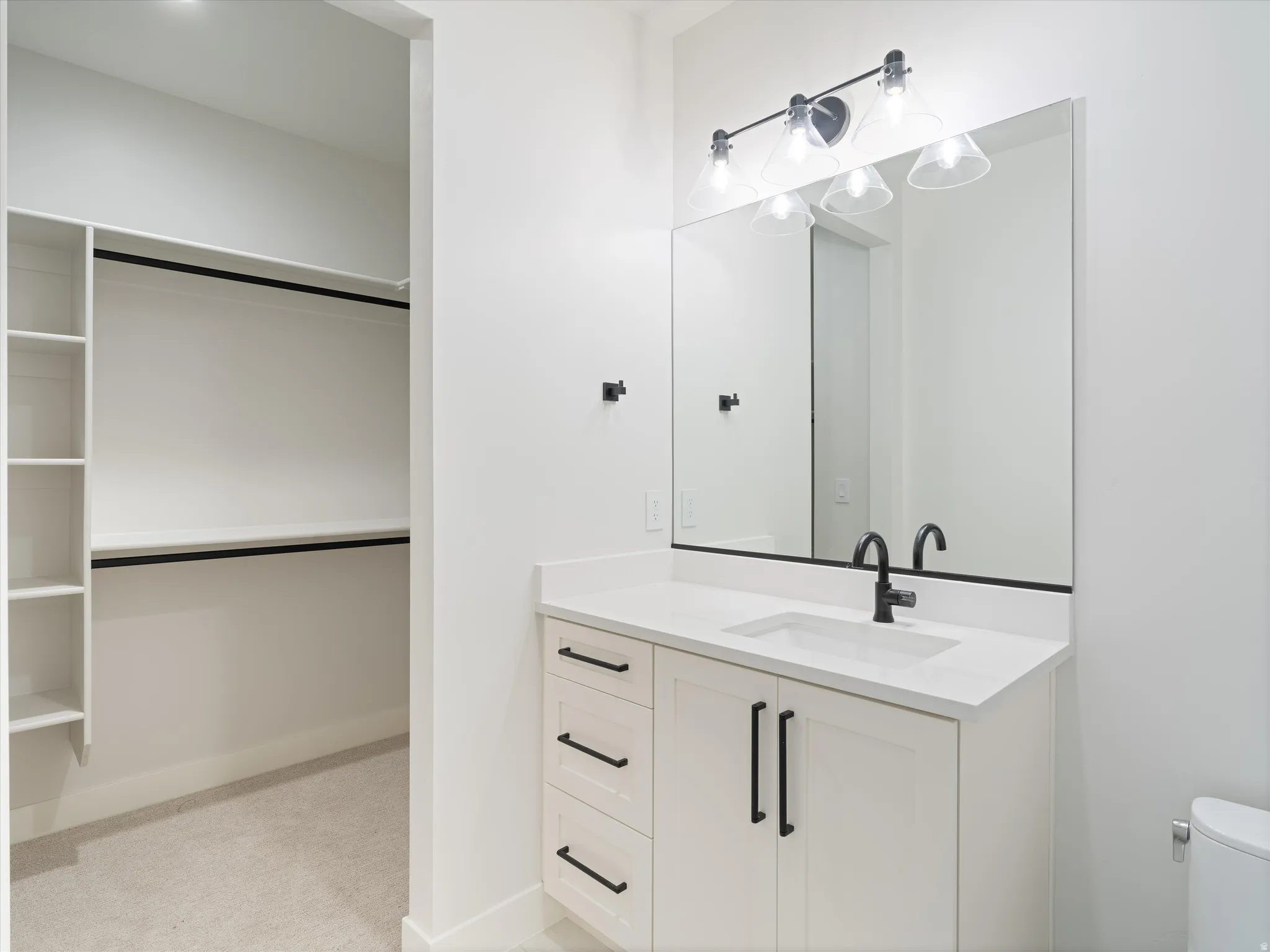 White vanity with quartz countertop, undermount sink, and matte black faucet