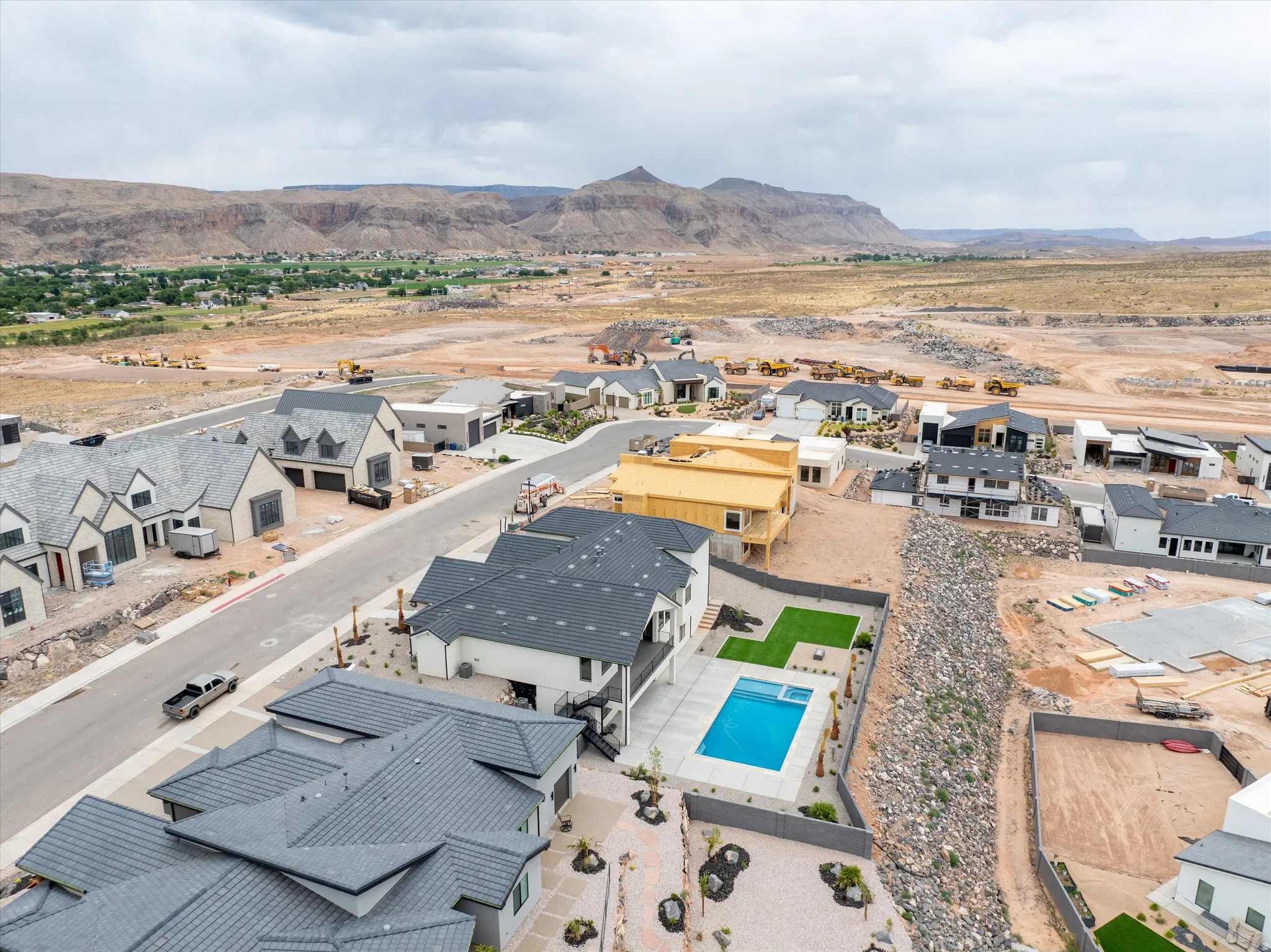 Contemporary home featuring a private pool with surrounding artificial turf and desert landscaping