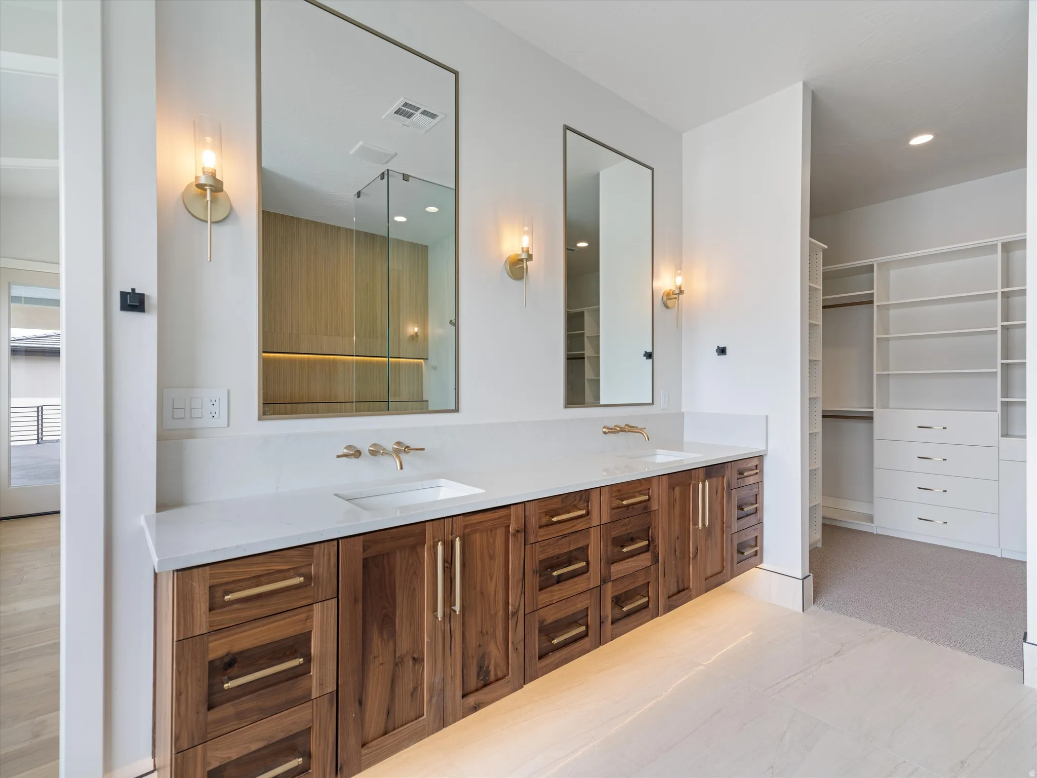 Dual vanity featuring wood-finish cabinetry, quartz countertops, and undermount sinks