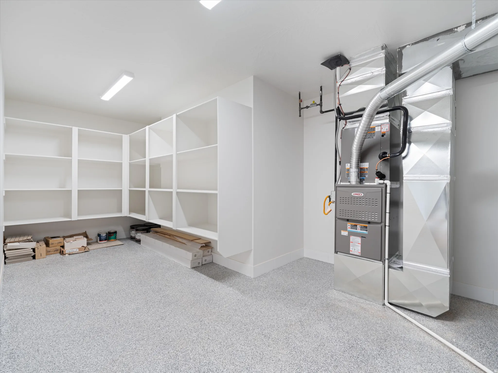 Utility space with built-in shelving, a Lennox furnace, and extensive ductwork