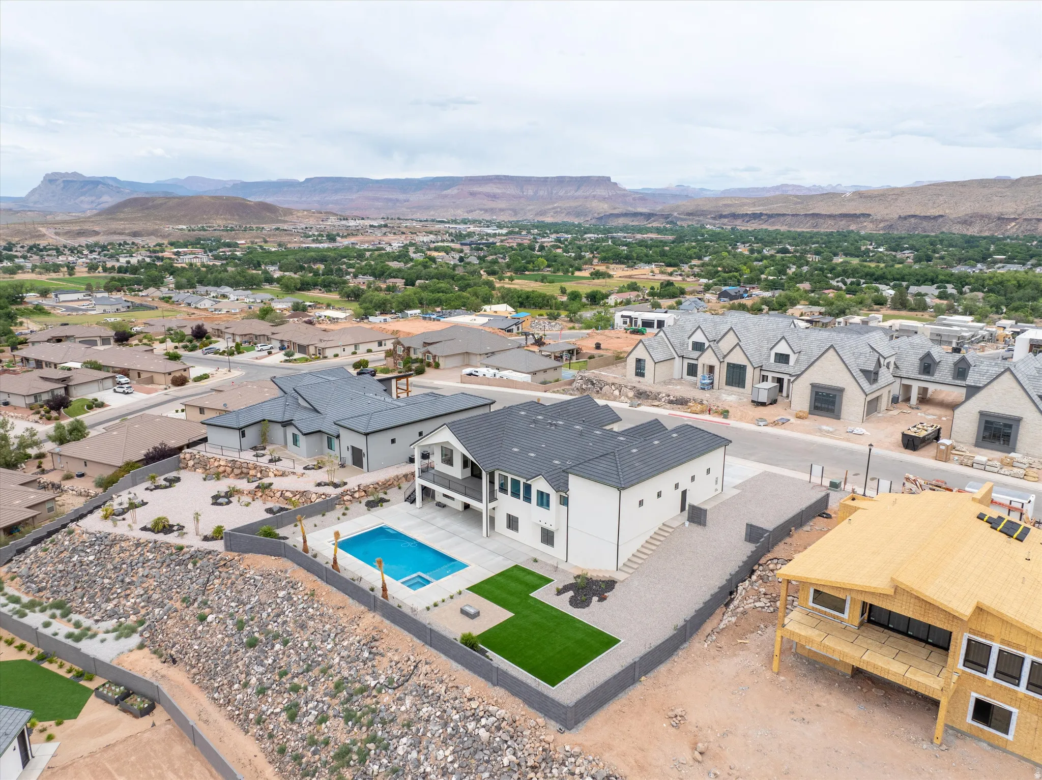 Contemporary residence featuring a private swimming pool, artificial turf area, and xeriscaped landscaping