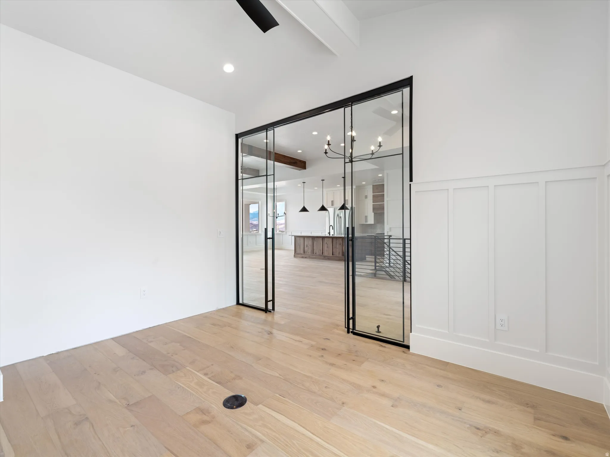 Light wood-finish flooring provides a neutral base for this space, highlighted by white walls and a panel accent wall