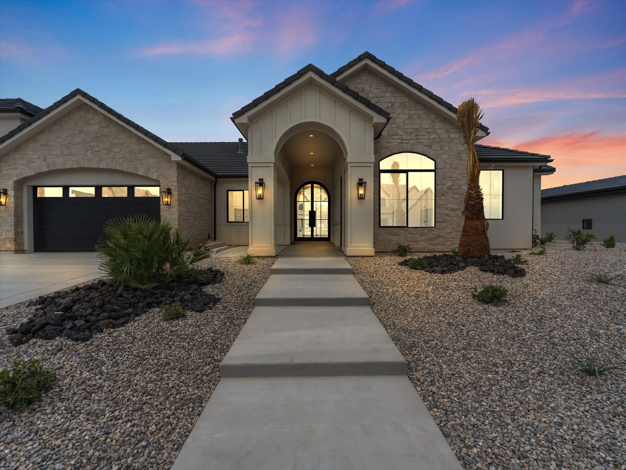 Contemporary exterior with stone facade and a prominent arched entry