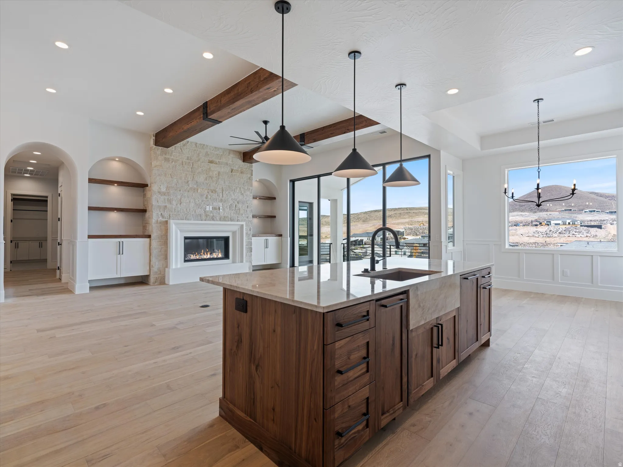 Central kitchen island with wood-finish cabinetry, integrated sink, and stone countertop