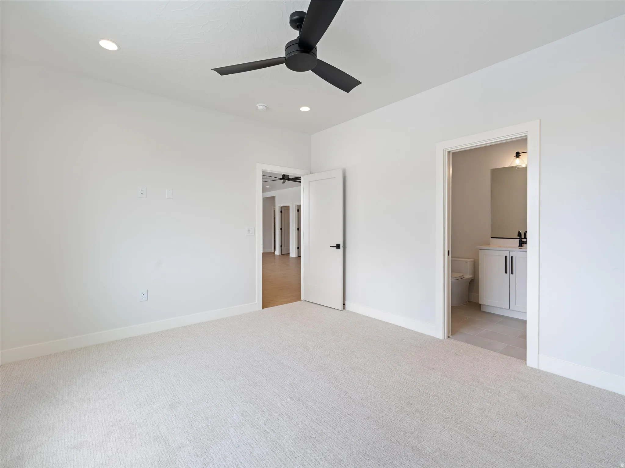 Carpeted room featuring a ceiling fan, recessed lighting, and white baseboards