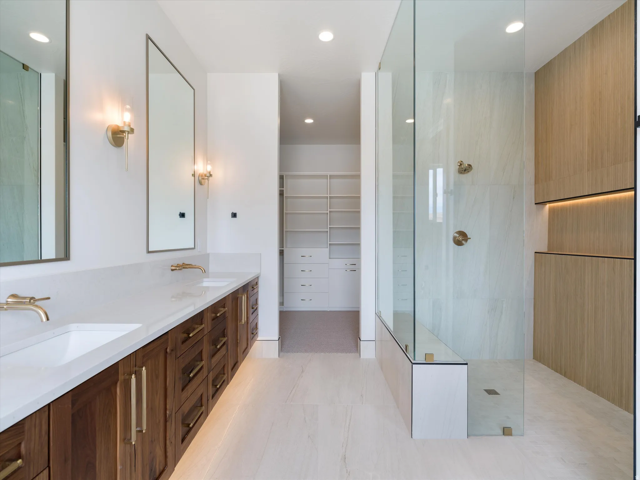 Dual floating vanities with quartz countertops, undermount sinks, and gold-toned fixtures