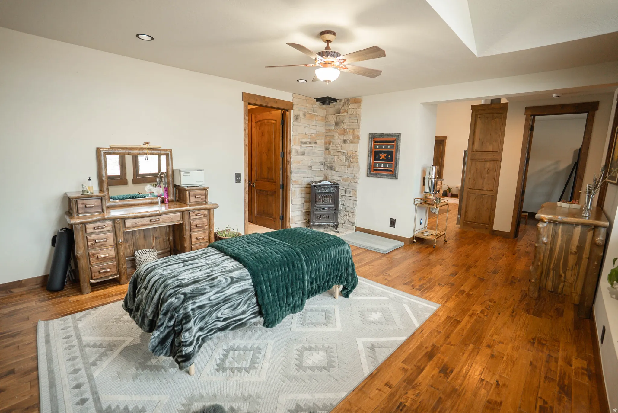 Spacious interior featuring wood-finish flooring, a stone accent wall, and recessed ceiling lighting