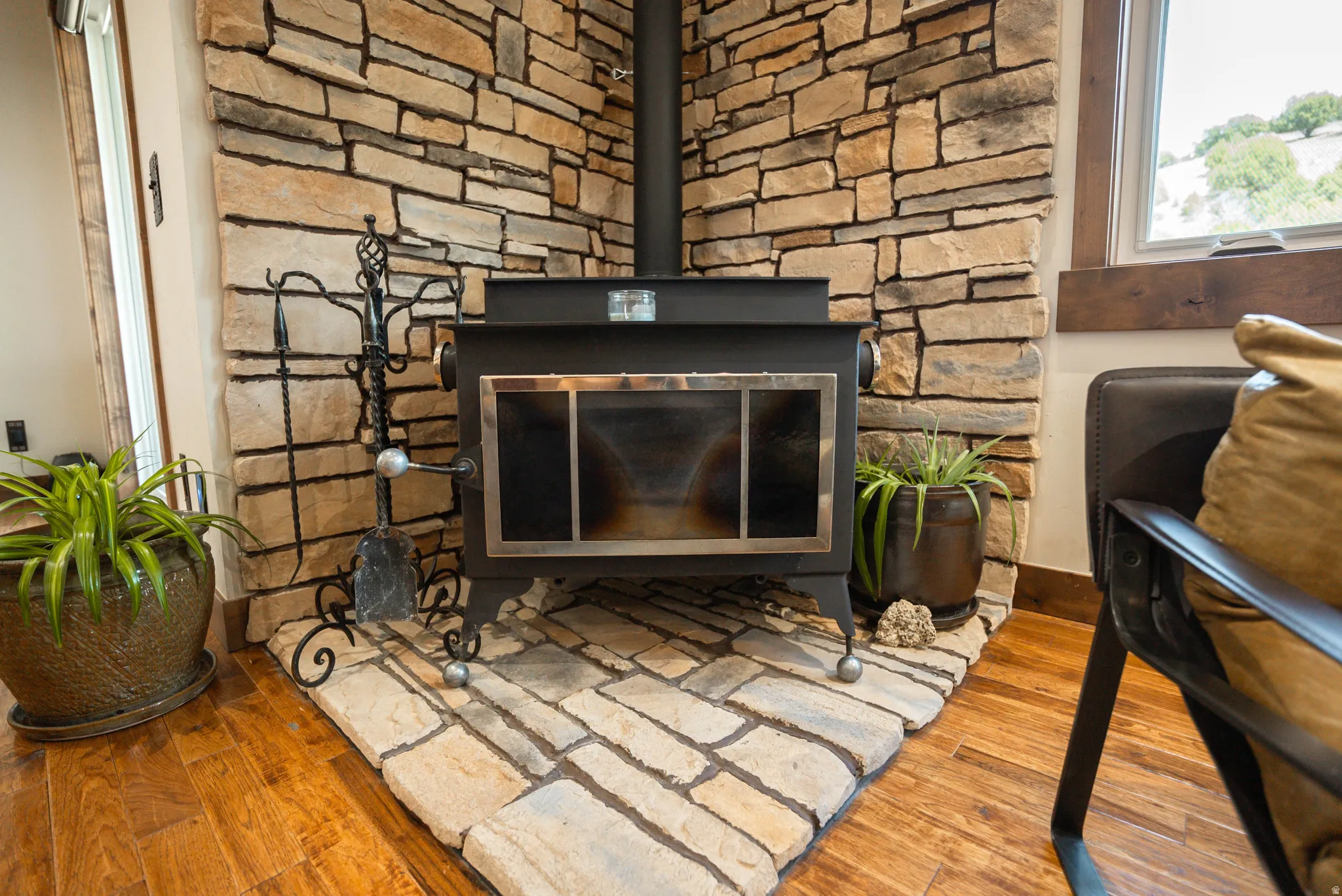Black wood-burning stove with a stone hearth and full stone surround