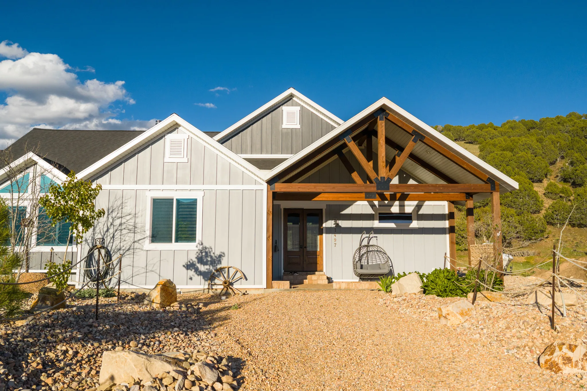 Modern farmhouse exterior with light gray vertical siding and white trim