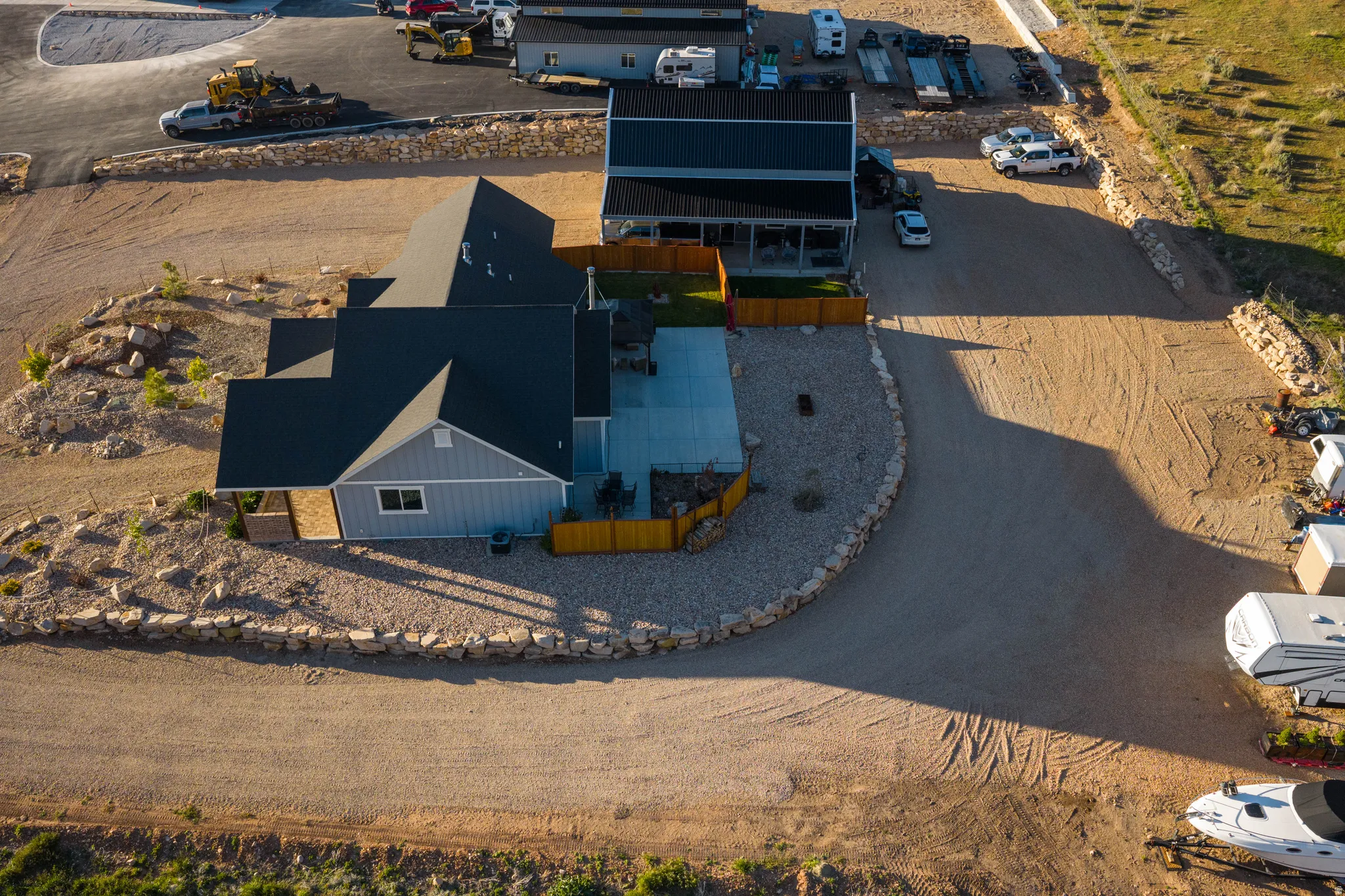 Contemporary residence with light blue siding and dark gray roofing, featuring a spacious concrete patio