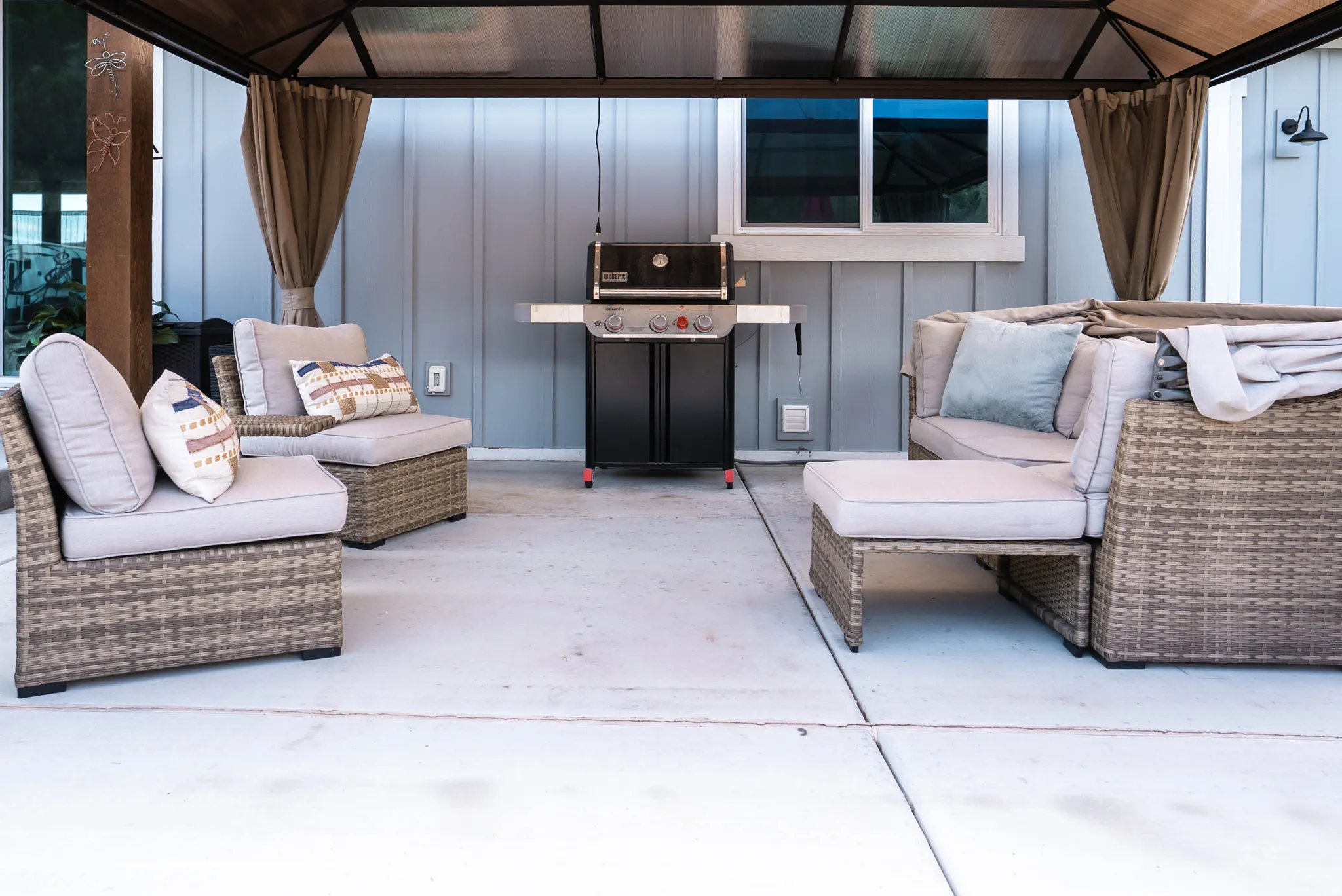 Covered patio featuring concrete flooring and a modern wall-mounted light fixture
