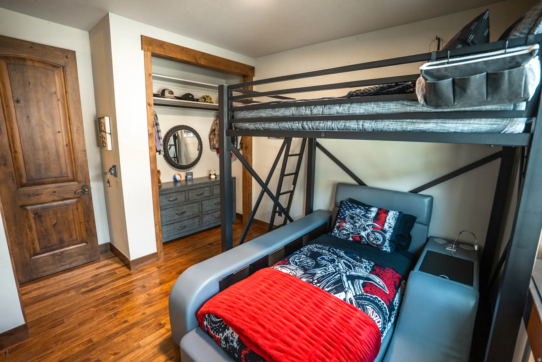 Hardwood flooring throughout, featuring a natural wood door with dark hardware and a recessed closet opening with wood trim
