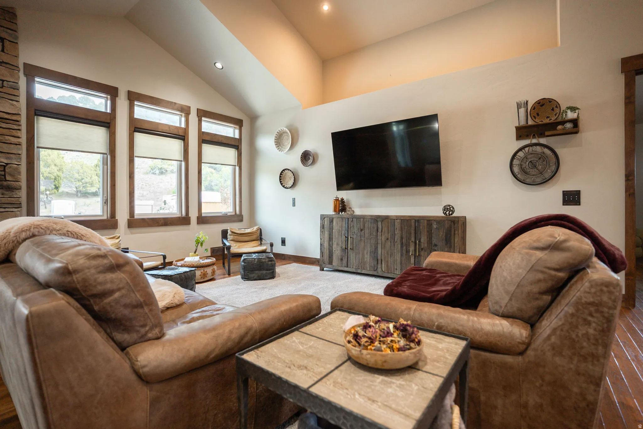 Spacious living area featuring a vaulted ceiling with recessed lighting