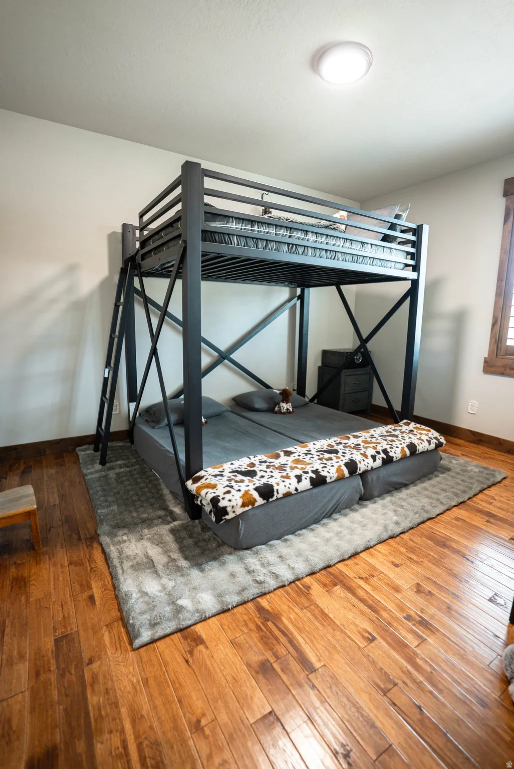 Room featuring wood-finish flooring, white walls, and a flush-mount ceiling light fixture