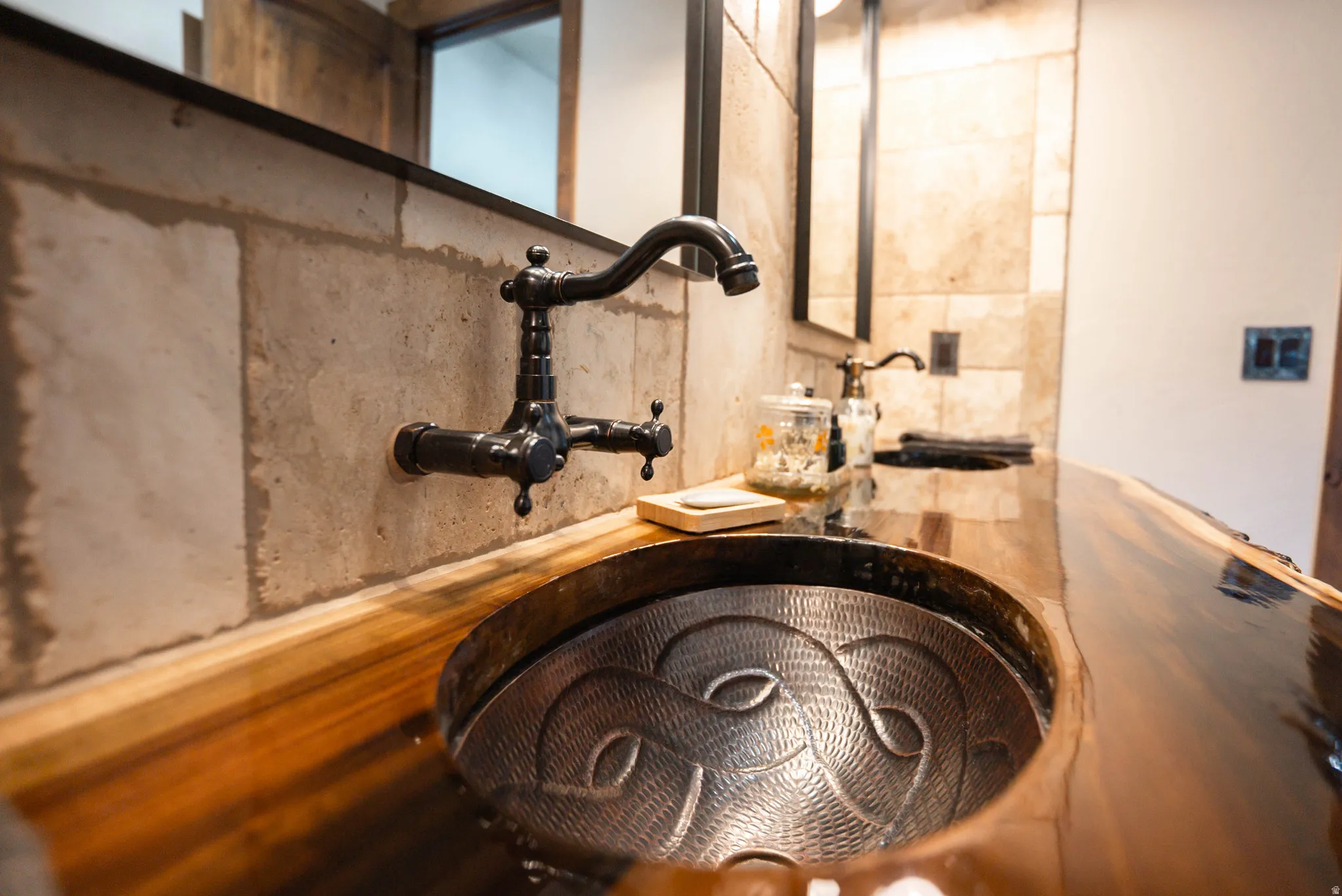 Artisan hammered metal sink basin set into a live-edge wood countertop