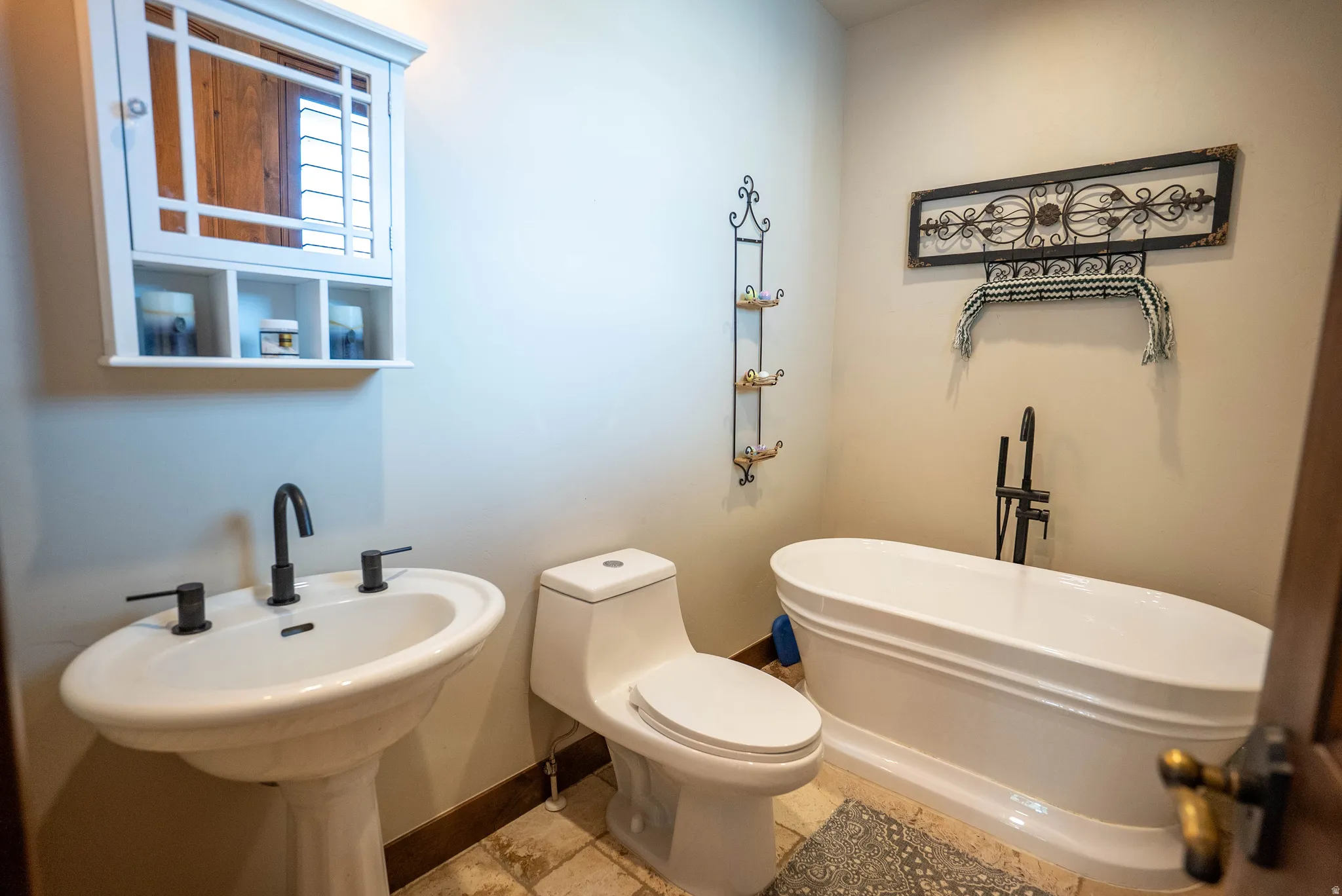 Freestanding soaking tub with a floor-mounted matte black faucet