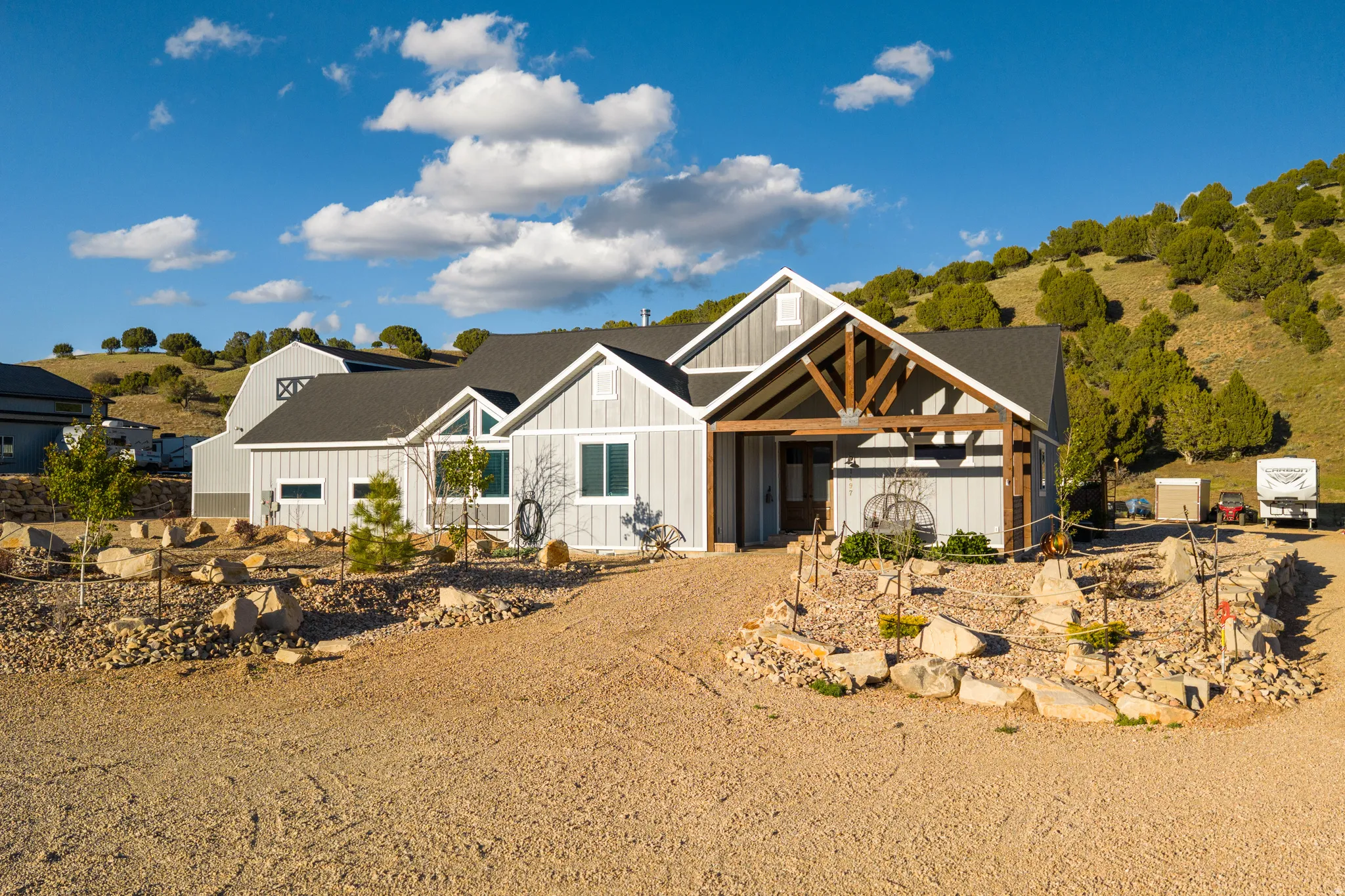 Contemporary farmhouse exterior with light gray siding and a dark shingle roof