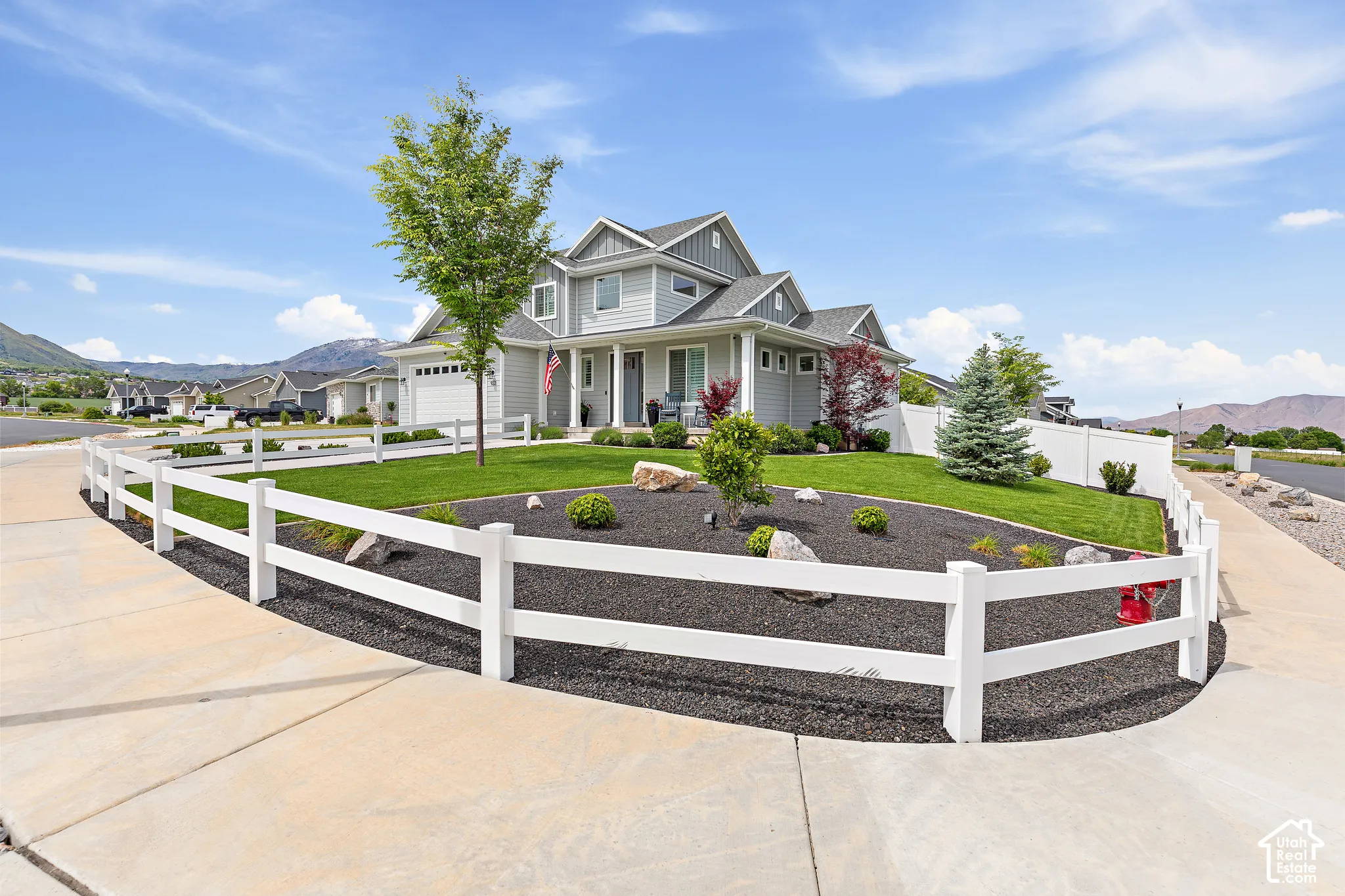 Light gray two-story residence featuring multiple gables and a covered front porch