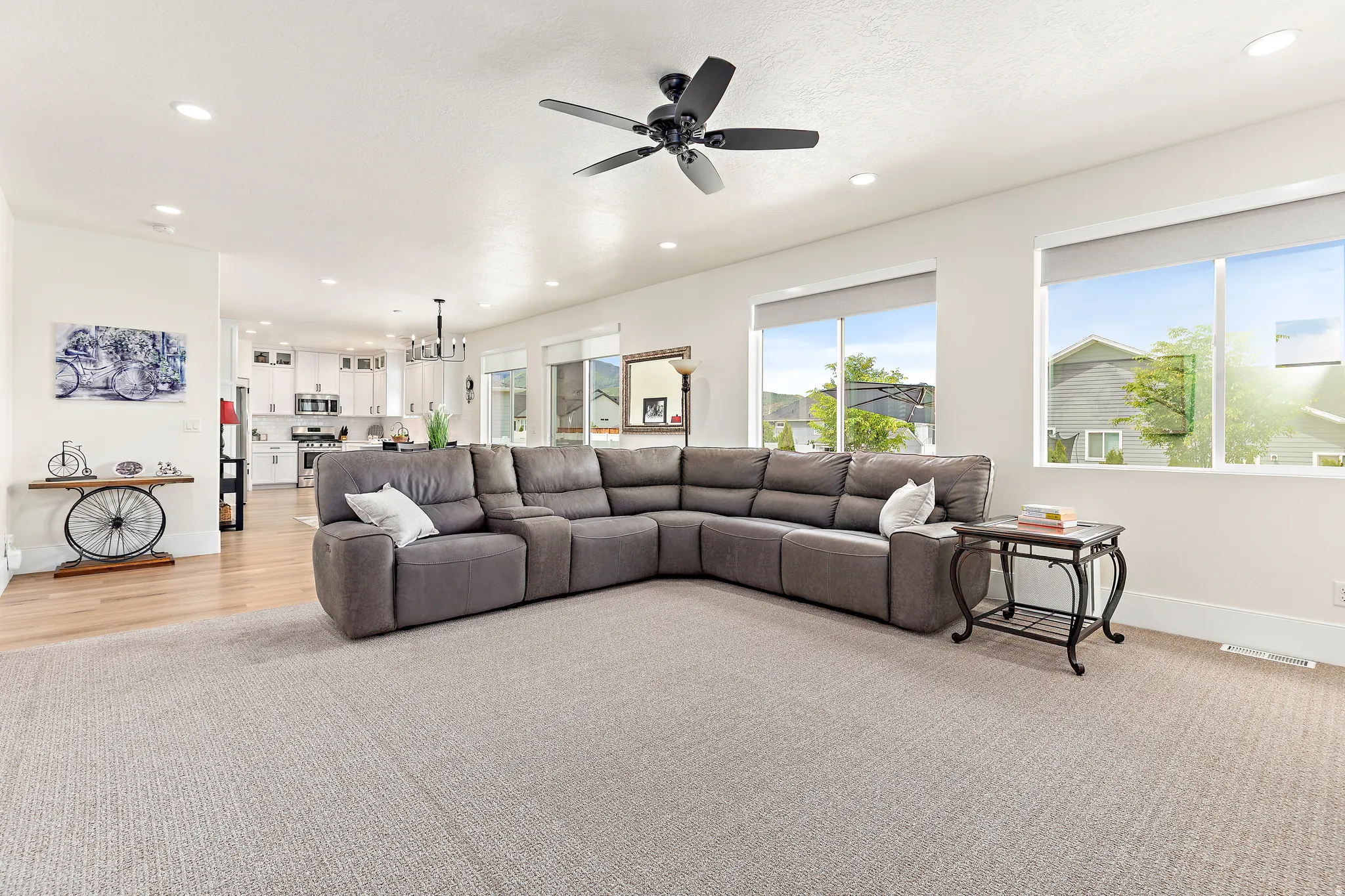 Open-concept living area featuring light-colored carpeting and recessed lighting