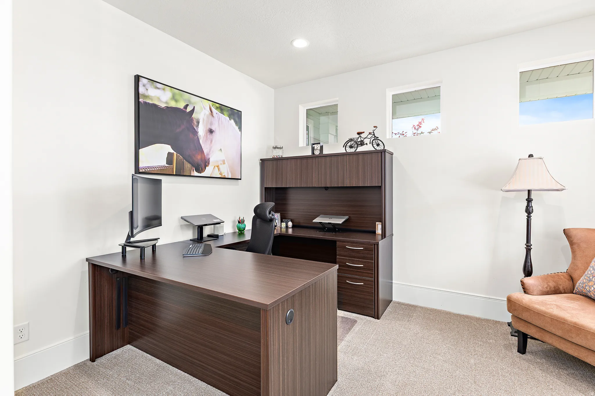 Dedicated office space featuring a built-in desk unit with overhead storage