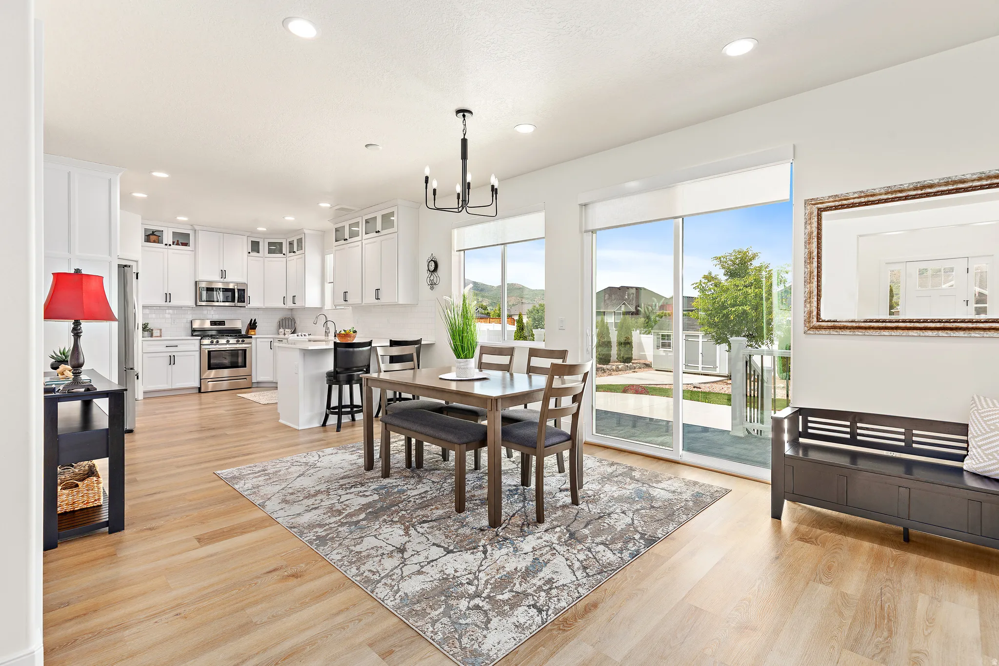 Open-concept living area featuring light wood-finish flooring, white walls, and recessed lighting