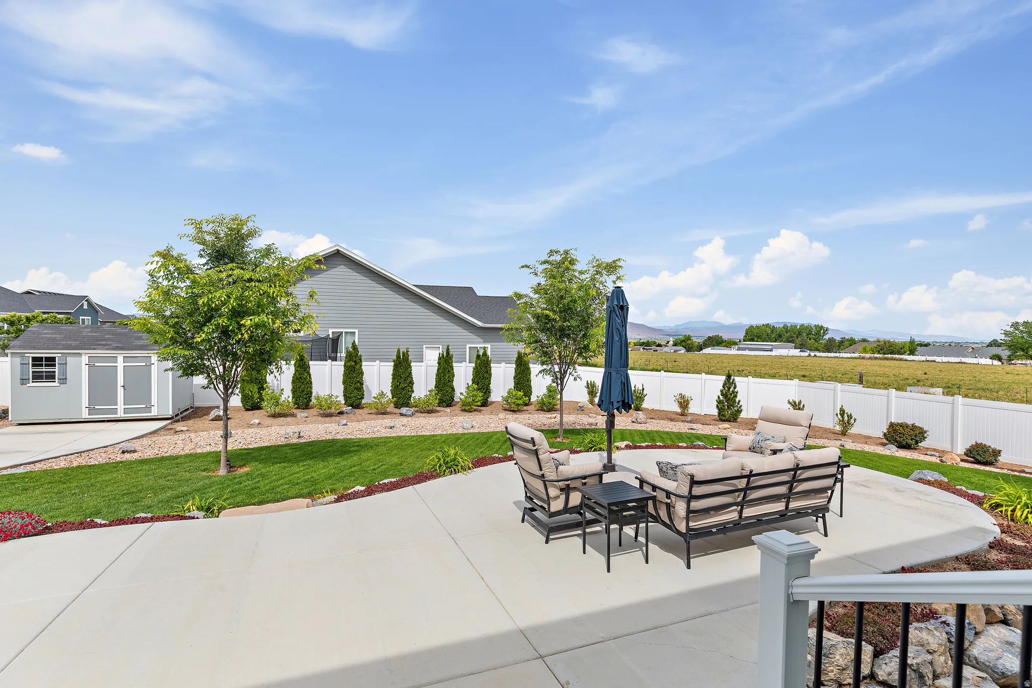 Expansive concrete patio area overlooking a manicured lawn