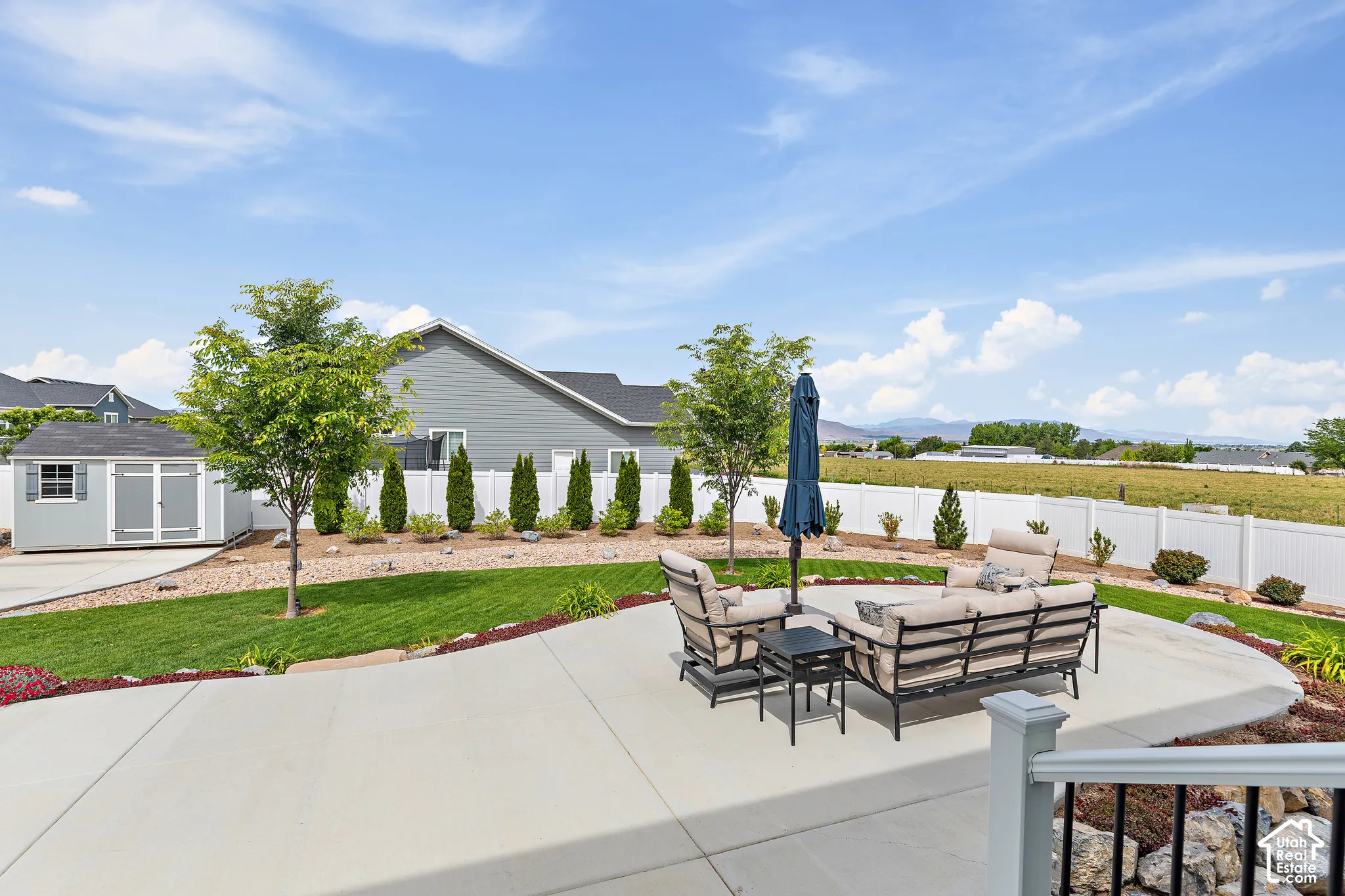 Expansive concrete patio area overlooking a manicured lawn