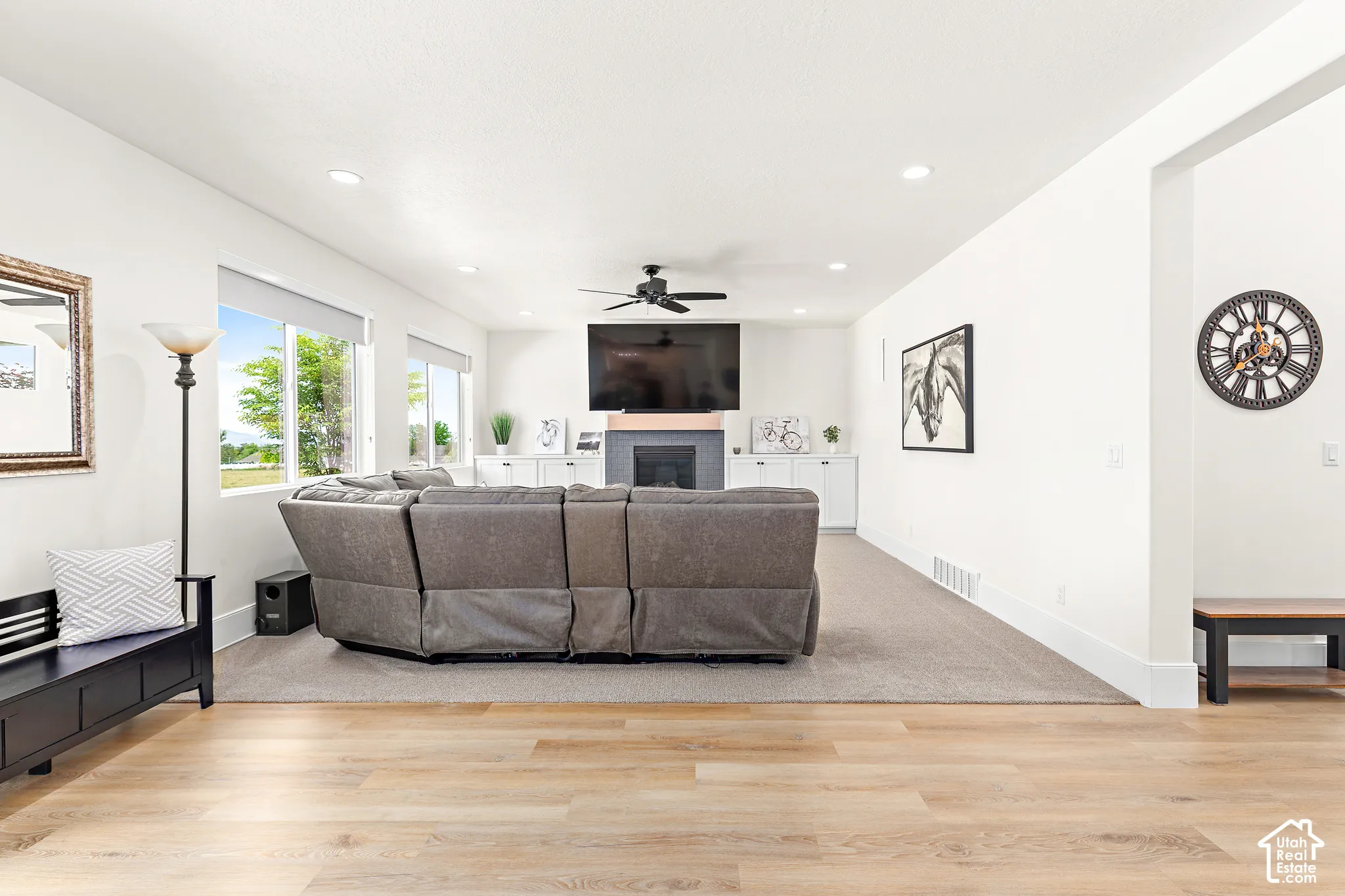 Open-concept living space featuring wood-finish flooring extending to a carpeted area