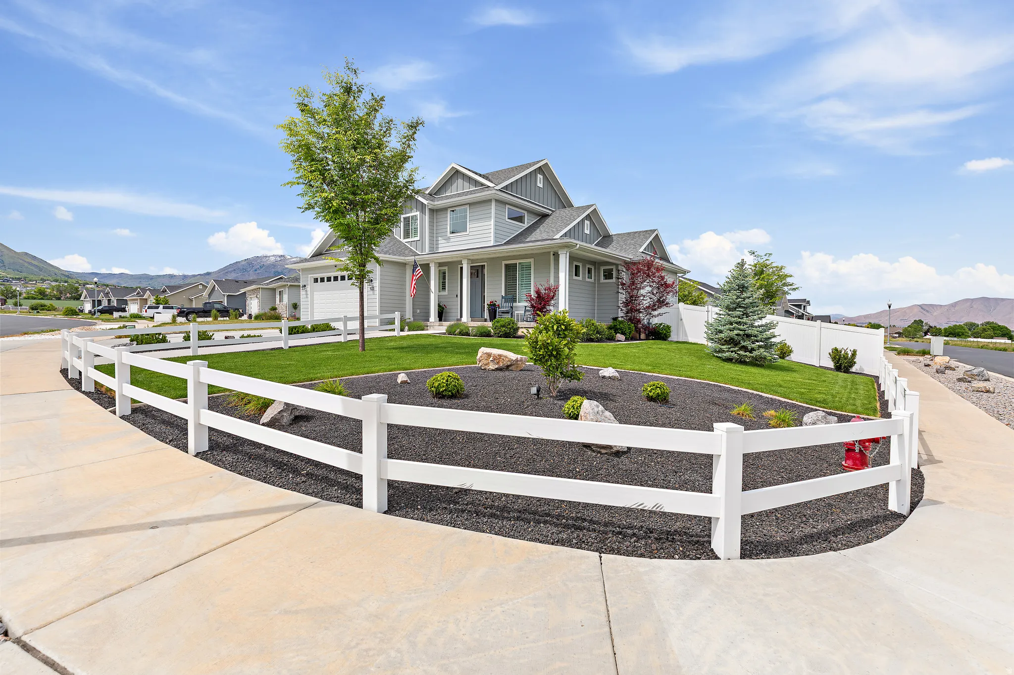 Light gray two-story residence featuring multiple gables and a covered front porch