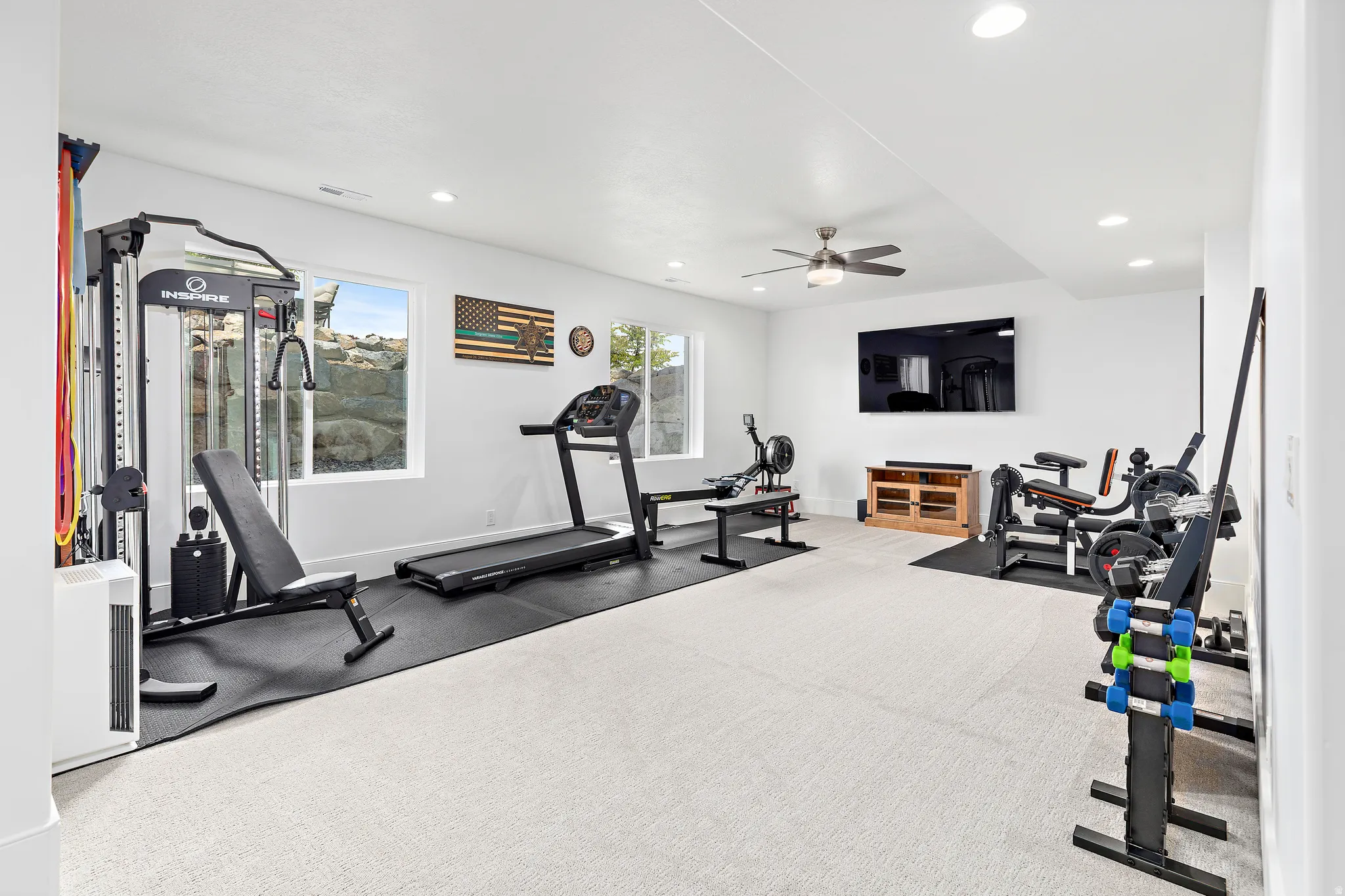 Spacious room featuring light-colored carpet flooring, recessed lighting, and a ceiling fan