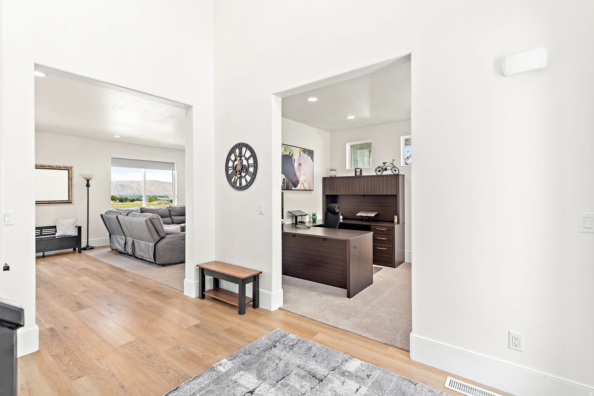 Open concept interior with light wood-finish flooring, recessed lighting, and a neutral color palette