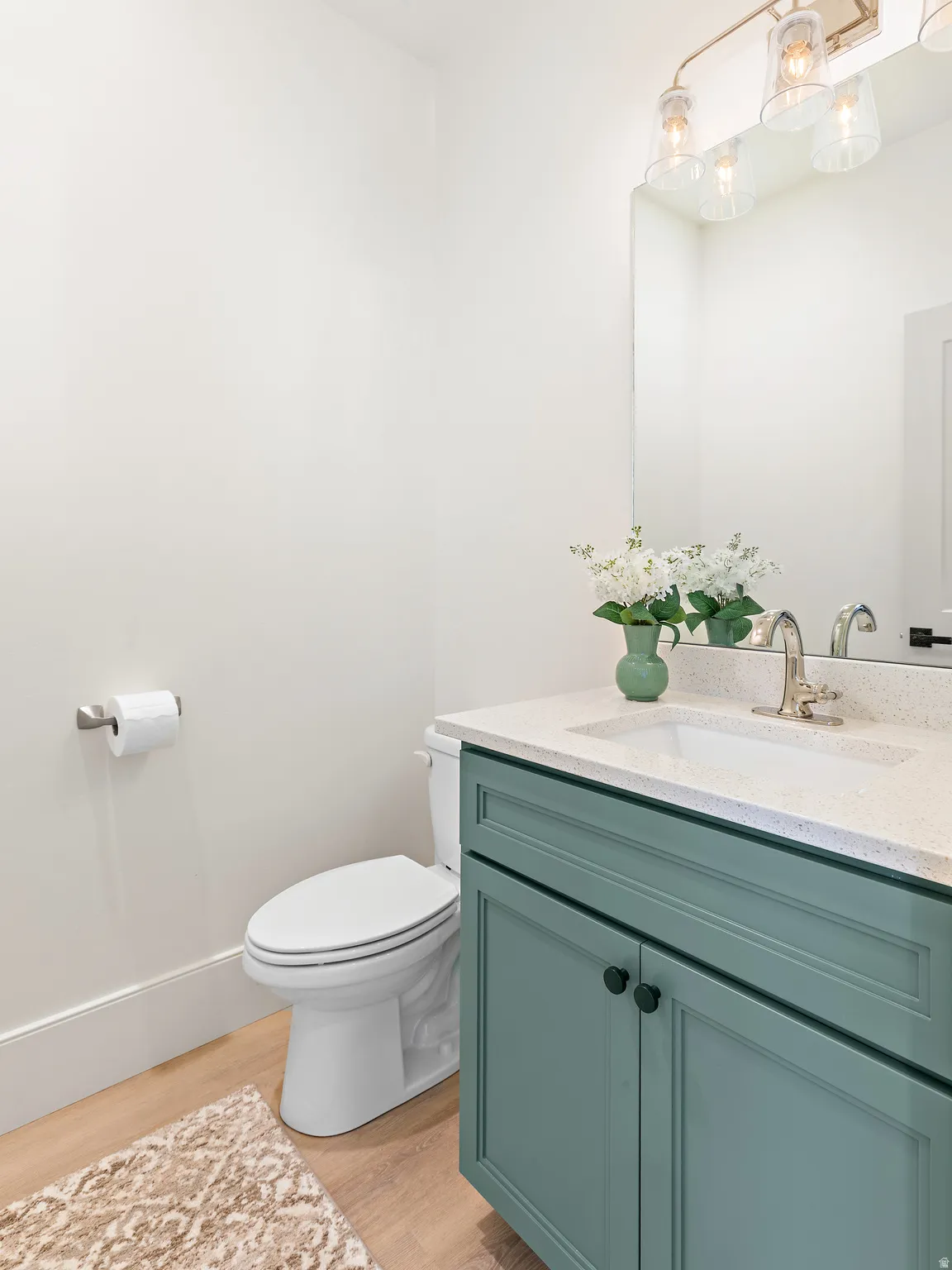 Bathroom vanity with a light-toned countertop, integrated sink, and an undermount faucet