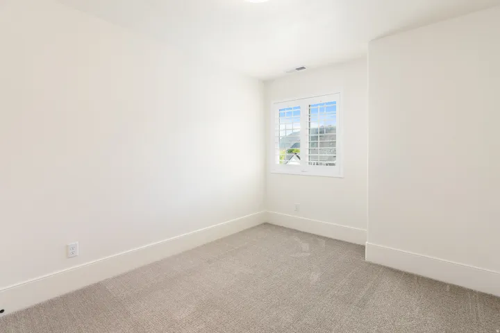 Bright room with neutral wall tones and plush grey carpeting