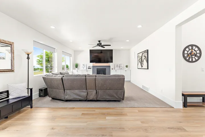 Open-concept living space featuring wood-finish flooring extending to a carpeted area
