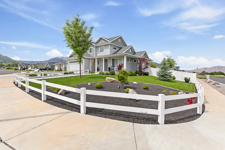 Light gray two-story residence featuring multiple gables and a covered front porch