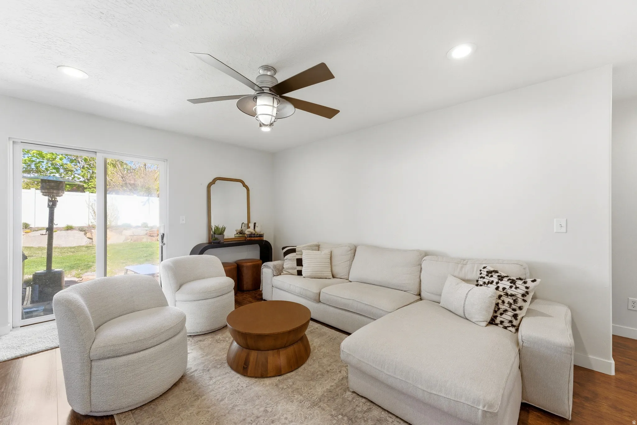 Bright living area featuring recessed lighting, a ceiling fan with integrated light, and wood-finish flooring