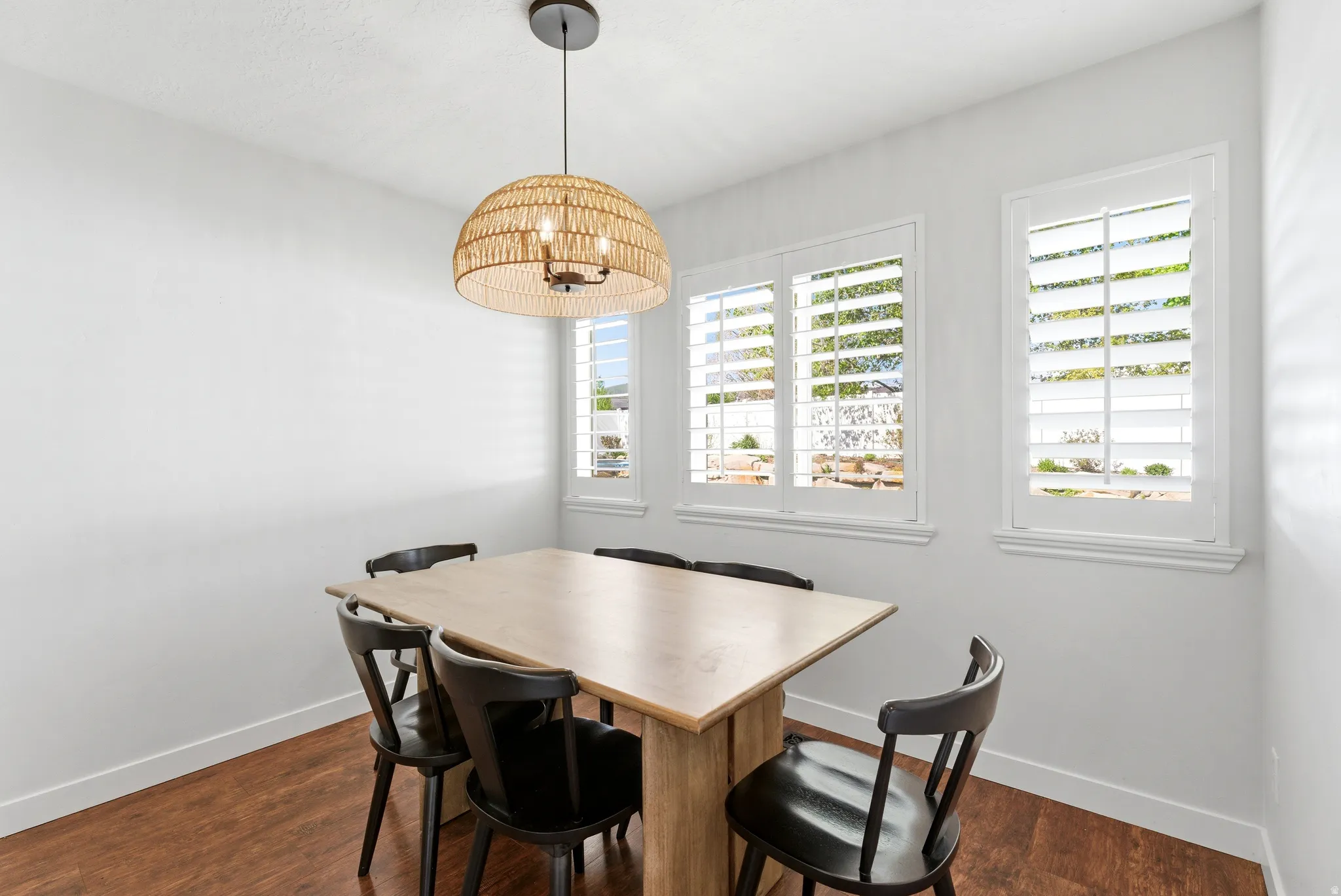 Bright interior space featuring wood-finish flooring, white baseboards, and clean white walls