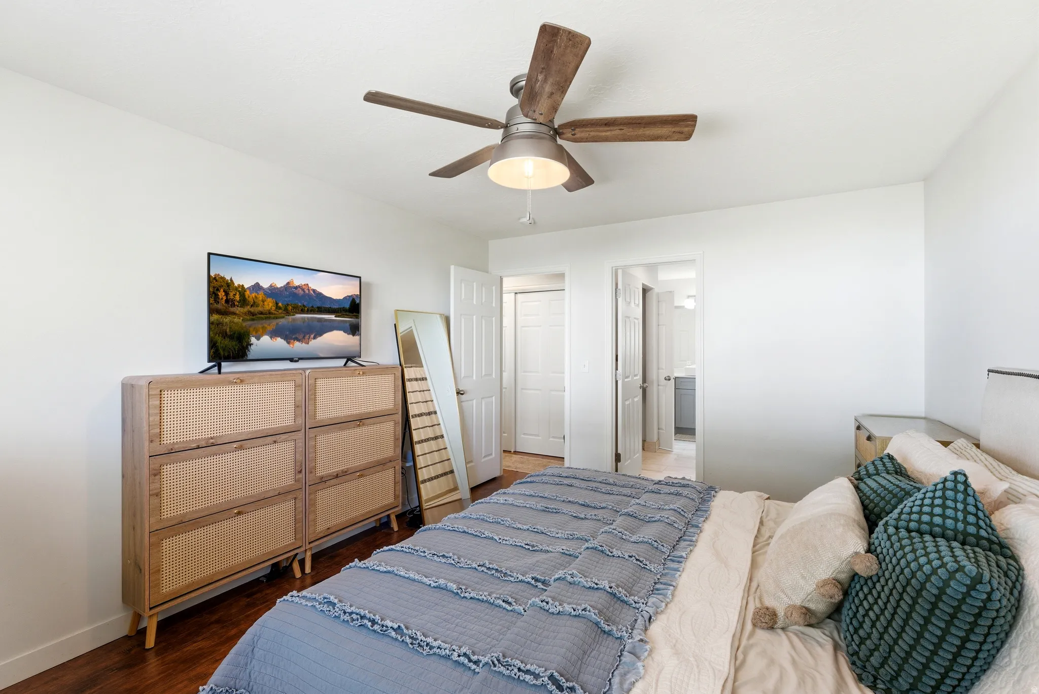 Bright interior space featuring wood-finish flooring and a ceiling fan with integrated lighting