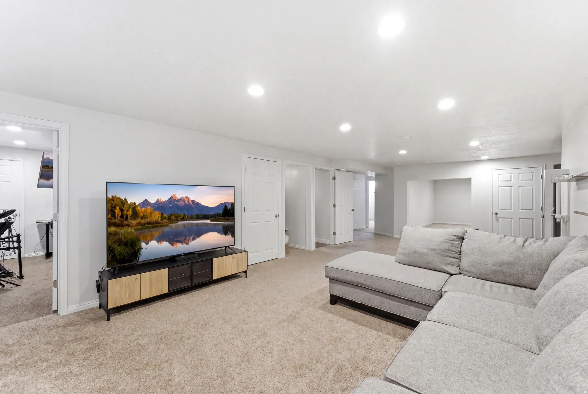 Spacious carpeted living area featuring recessed lighting, multiple interior doors, and a built-in media niche