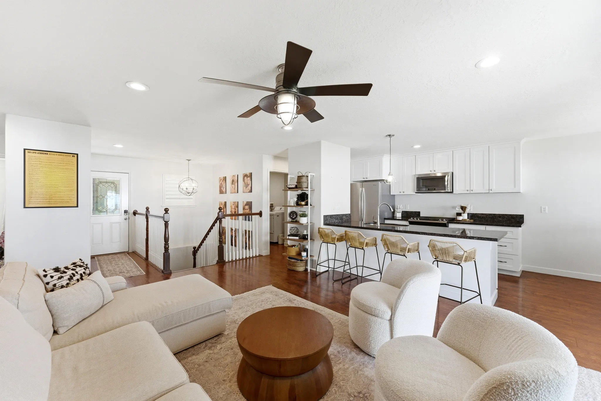 Open-concept living area featuring rich wood-finish flooring, recessed lighting, and a contemporary ceiling fan