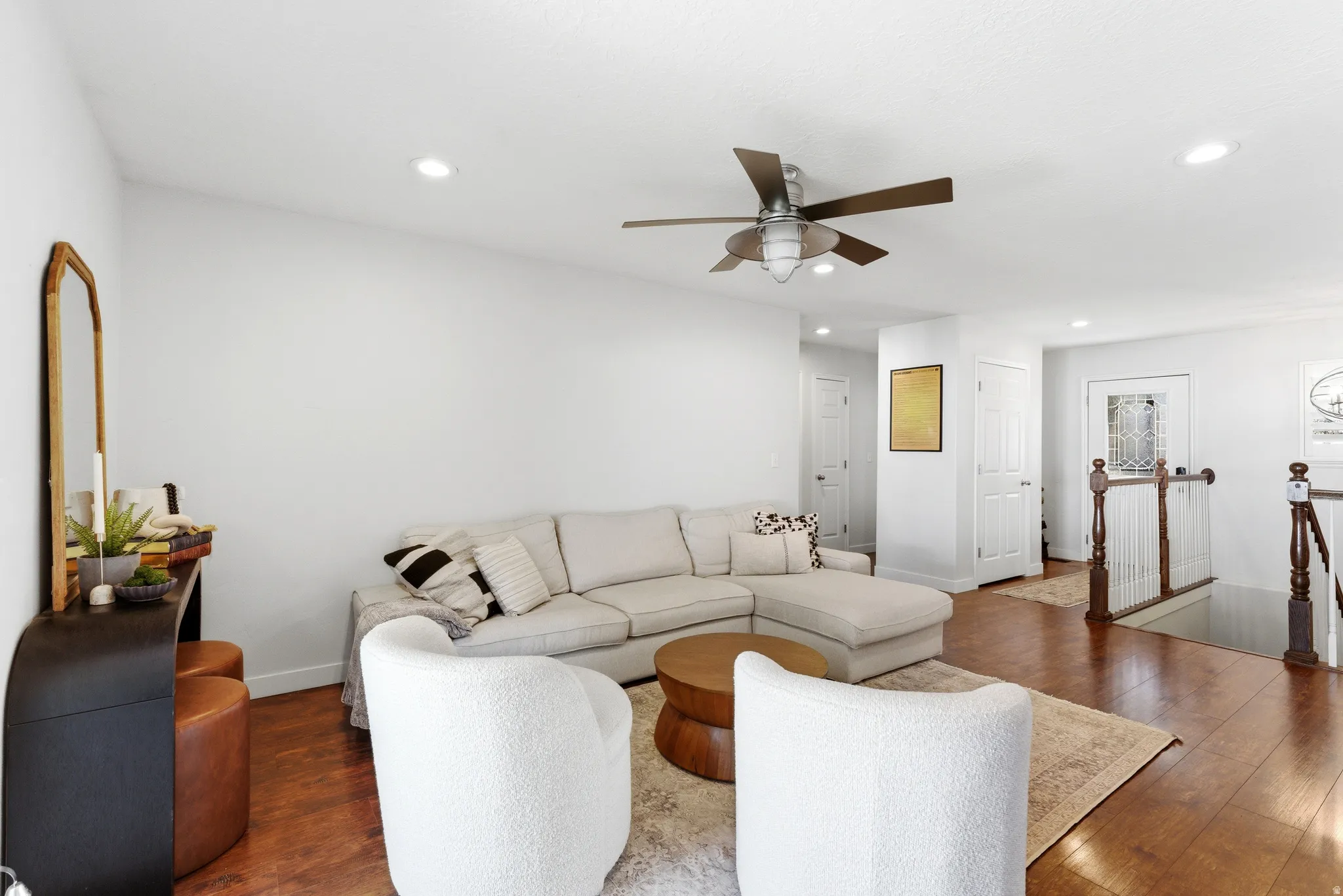 Open-concept living space featuring wood-finish flooring, recessed lighting, and a ceiling fan